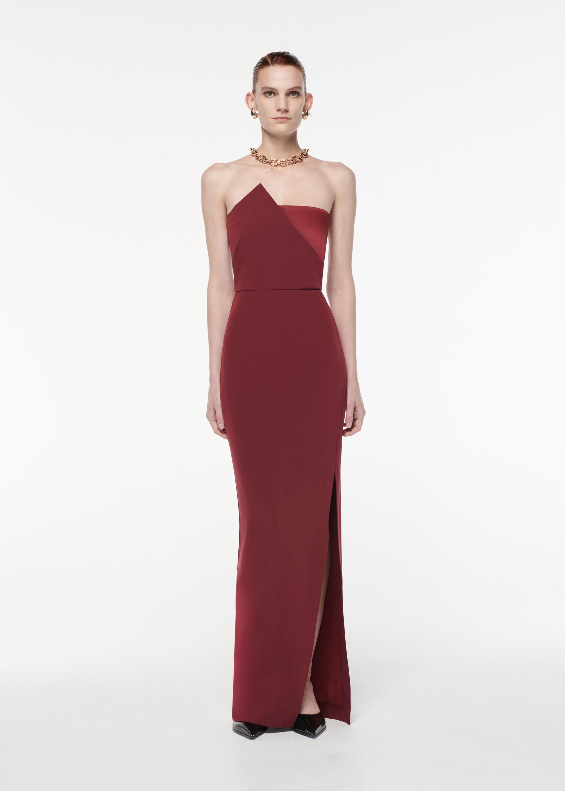 A photograph of a woman wearing a Strapless Satin Crepe Gown in Burgundy