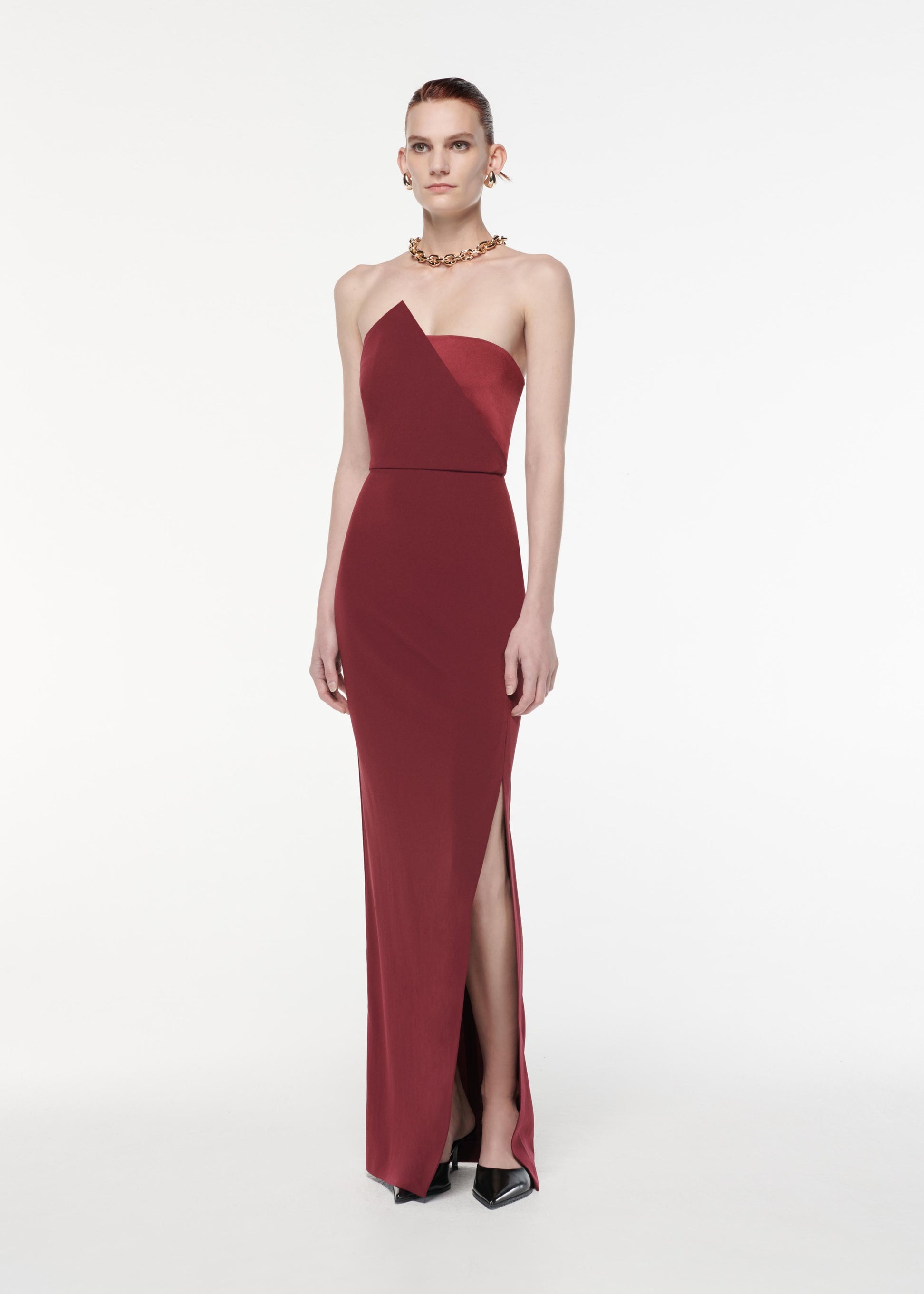 A photograph of a woman wearing a Strapless Satin Crepe Gown in Burgundy