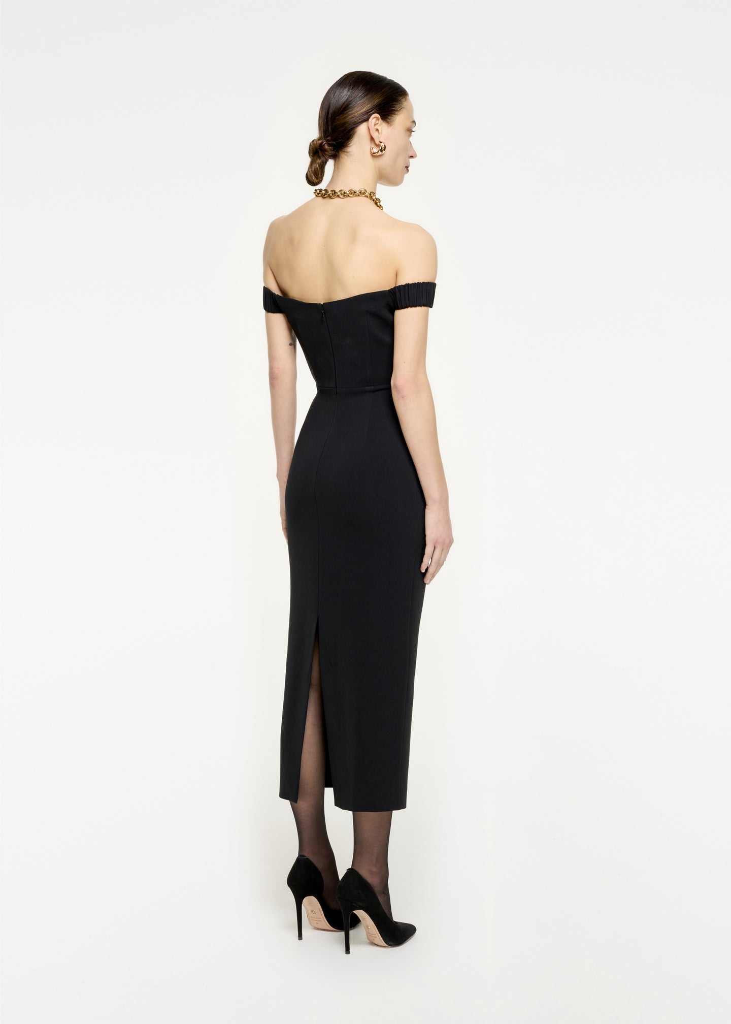 The back of a woman wearing the Off The Shoulder Stretch Cady Midi Dress in Black