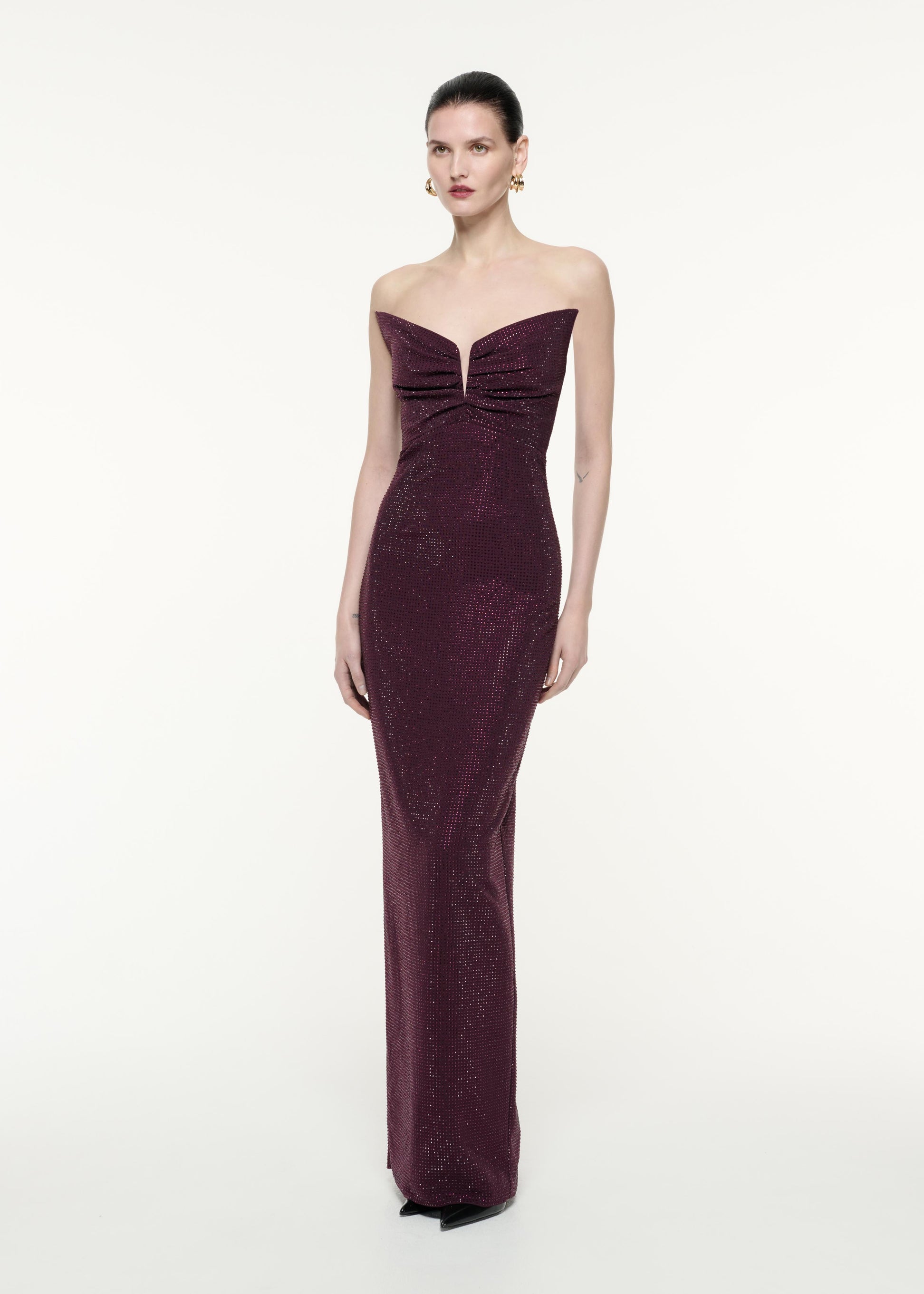 A side view image of a model wearing the Strapless Diamante Gown in Aubergine