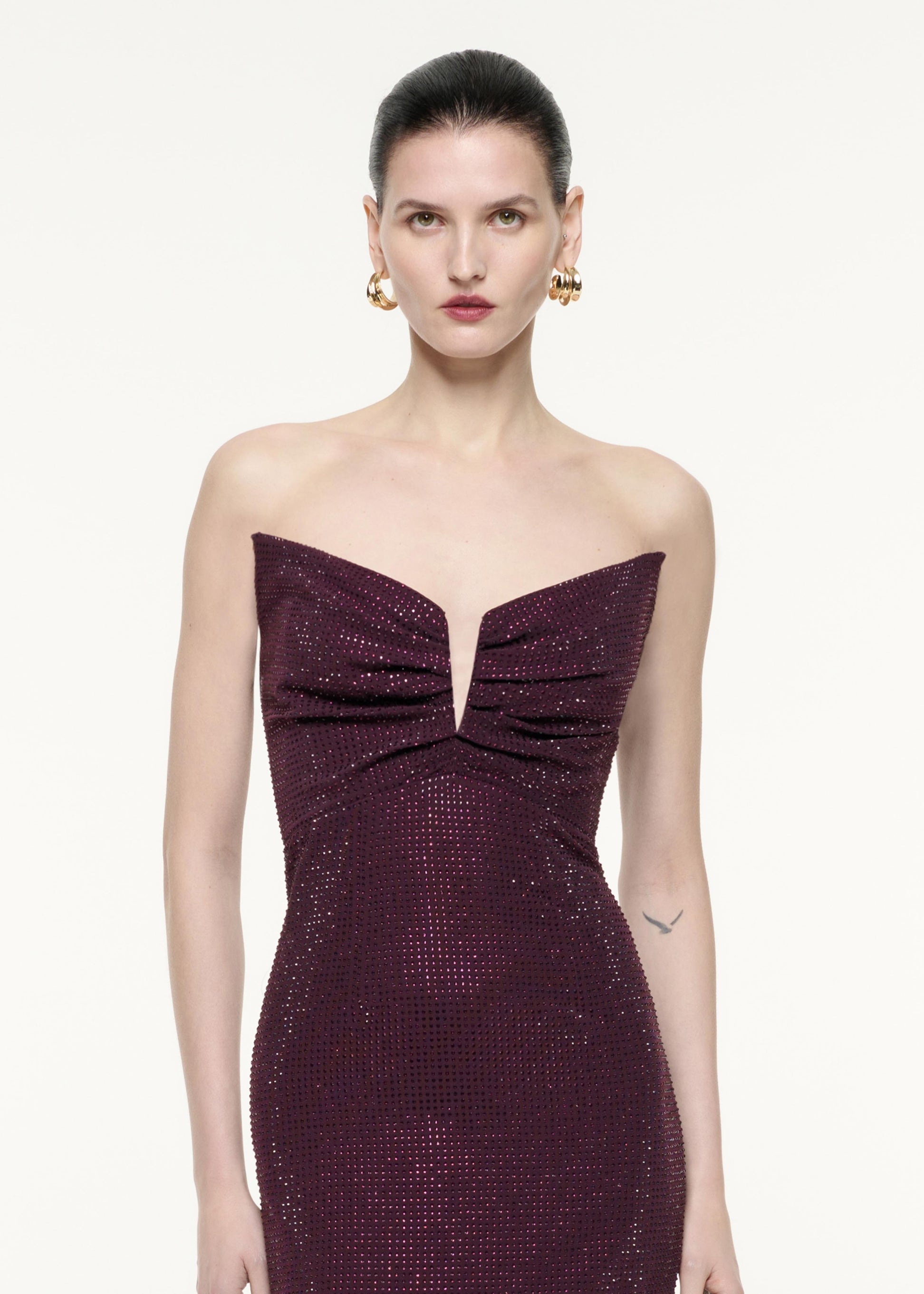 A close up image of a model wearing the Strapless Diamante Gown in Aubergine