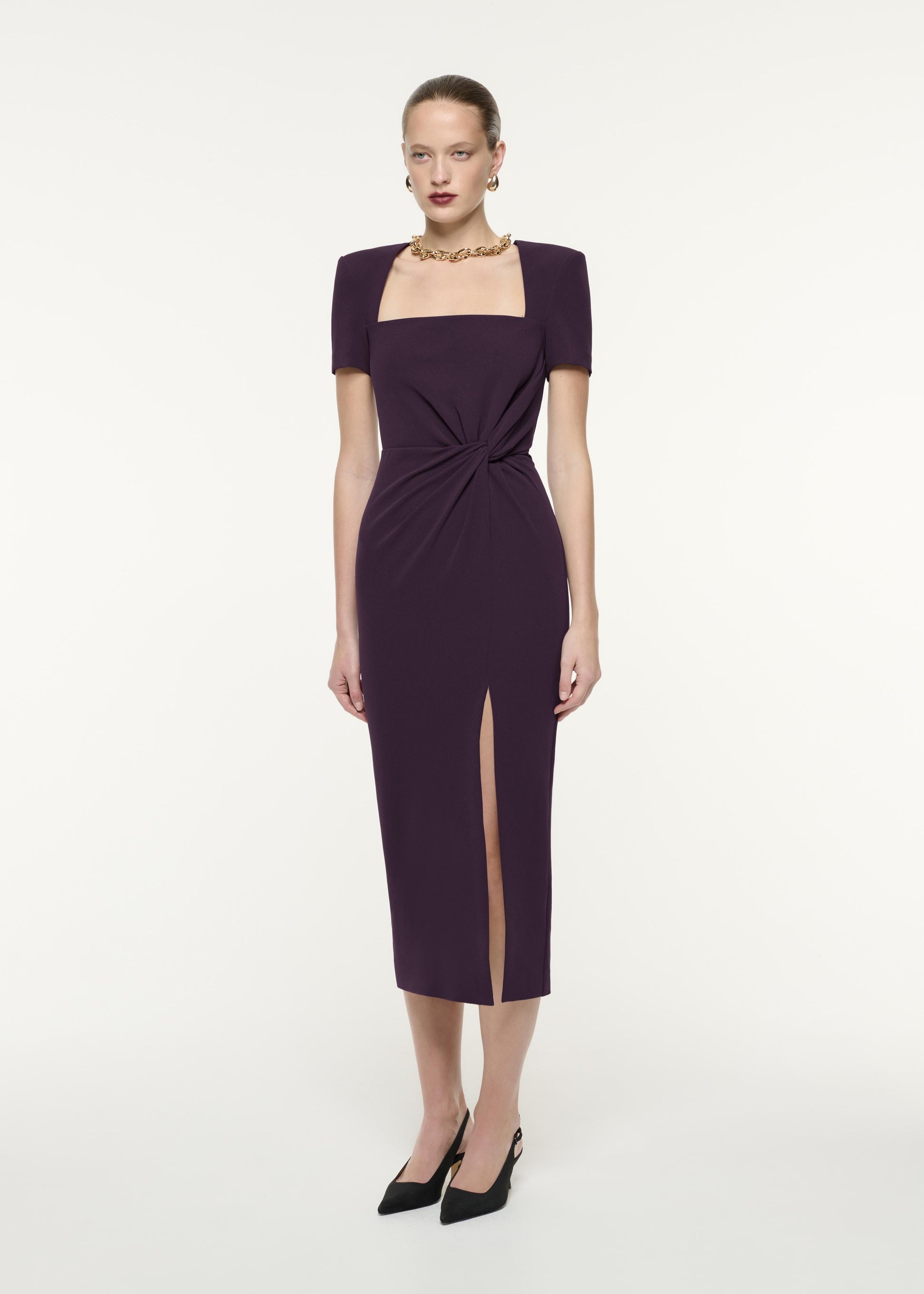 A side view image of a model wearing the Short Sleeve Heavy Cady Midi Dress in Aubergine