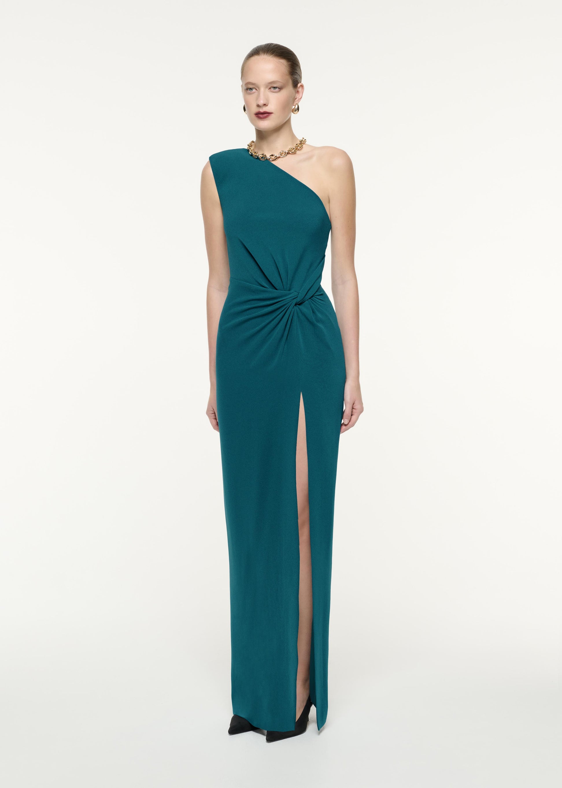 A side view image of a model wearing the Asymmetric Satin Crepe Maxi Dress in Green