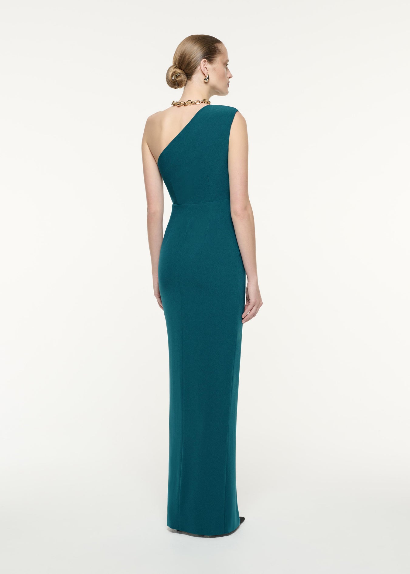 A back view image of a model wearing the Asymmetric Satin Crepe Maxi Dress in Green