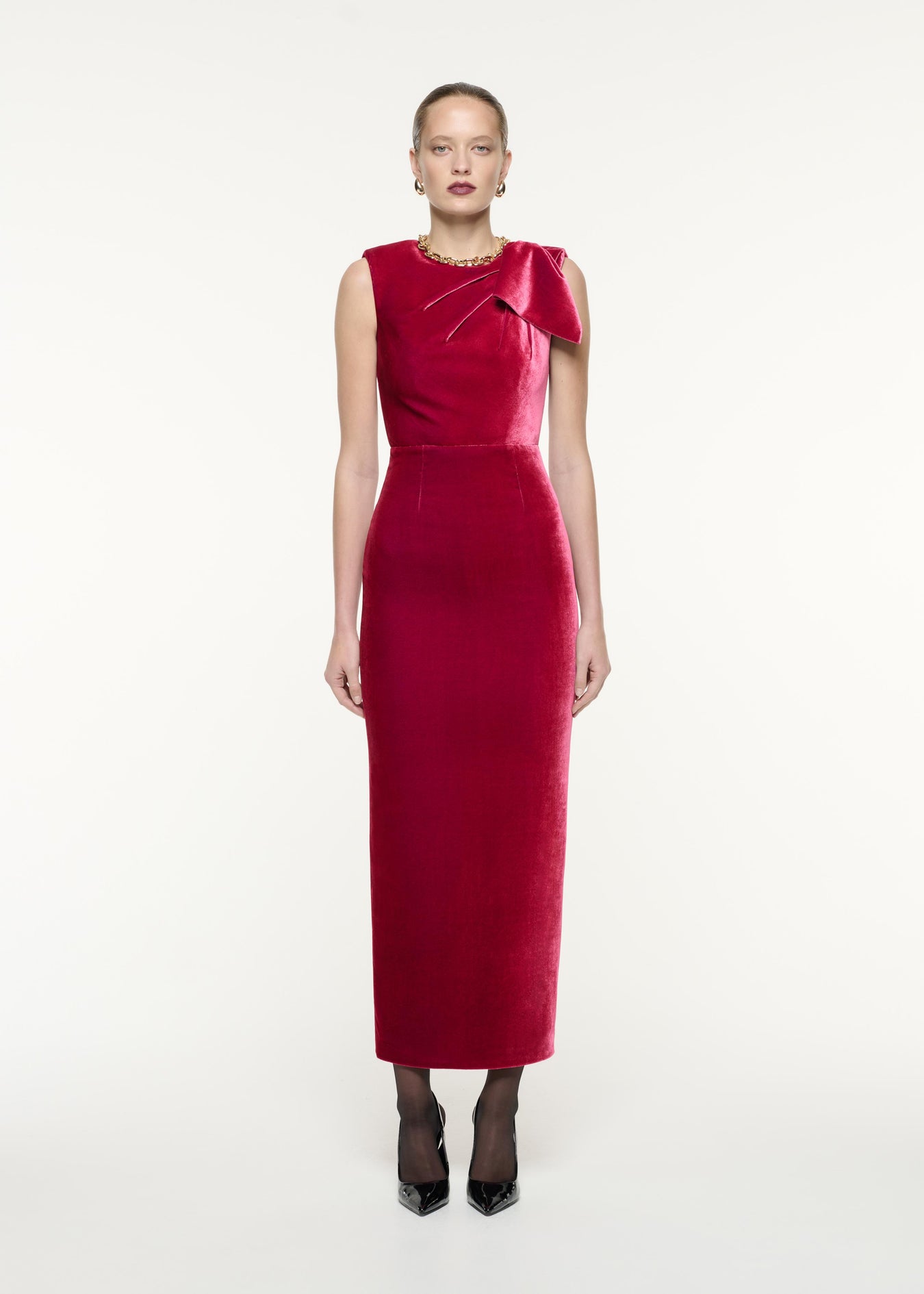 A front view image of a model wearing the Velvet Bow Maxi Dress in Pink
