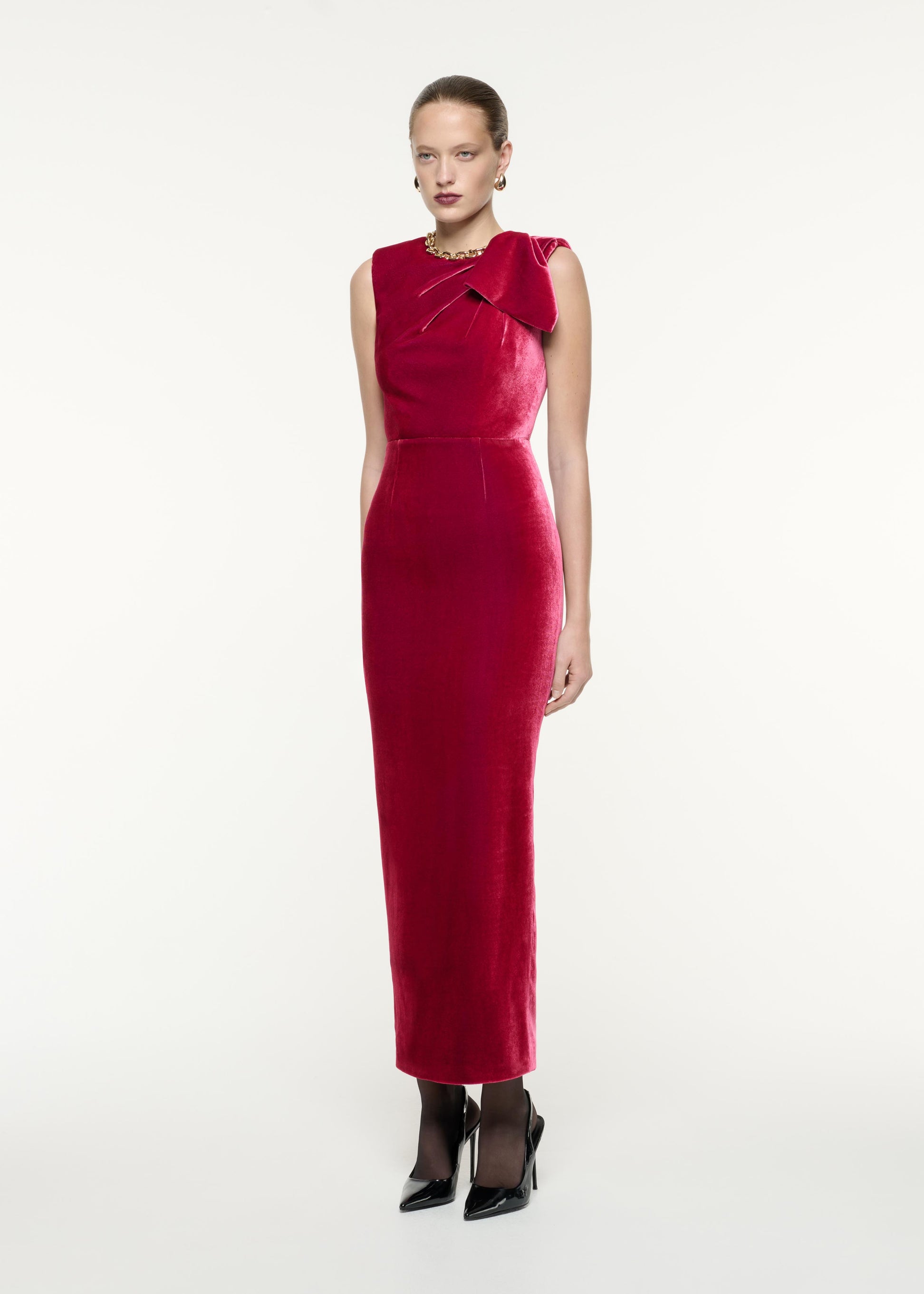 A side view image of a model wearing the Velvet Bow Maxi Dress in Pink