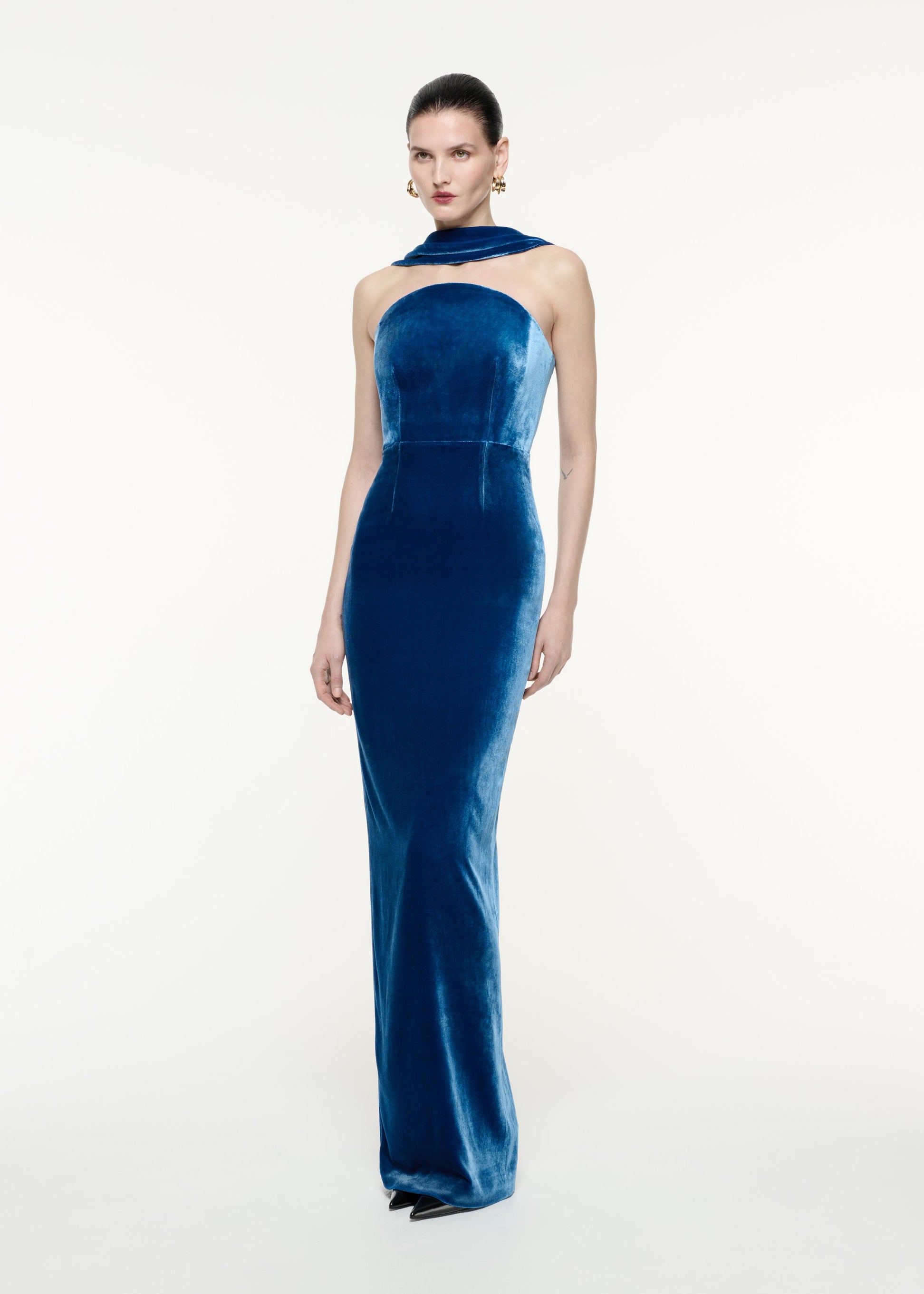 A side view image of a model wearing the Velvet Sash Gown in Navy