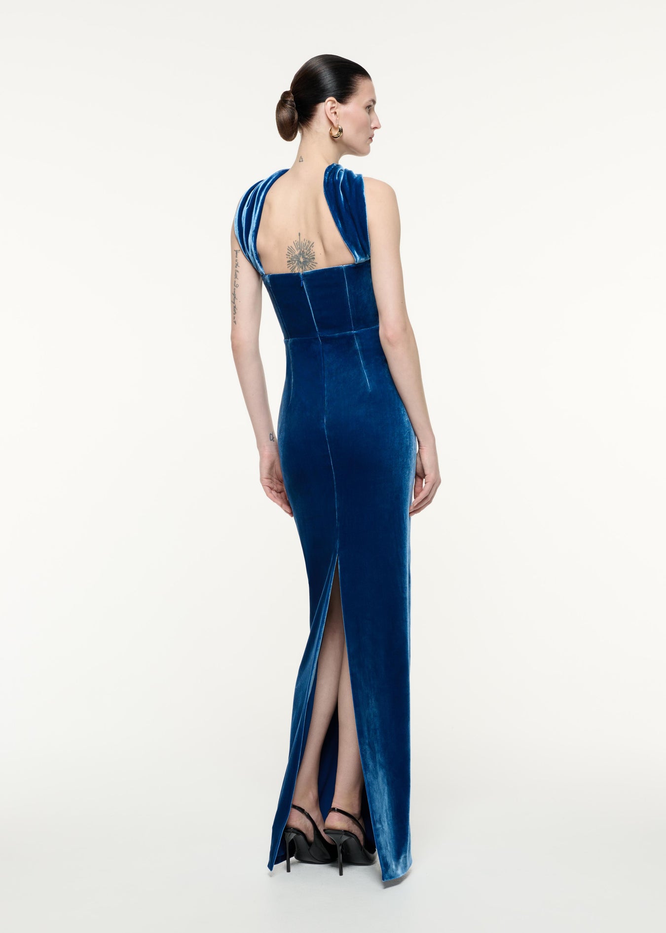 A back view image of a model wearing the Velvet Sash Gown in Navy