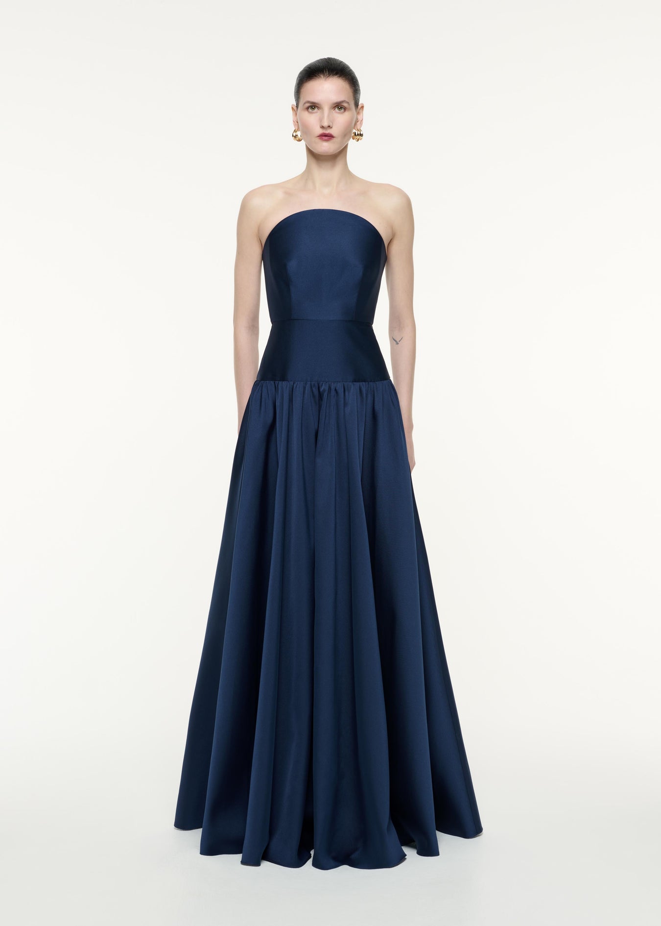 A front view image of a model wearing the Strapless Taffeta Gown in Navy