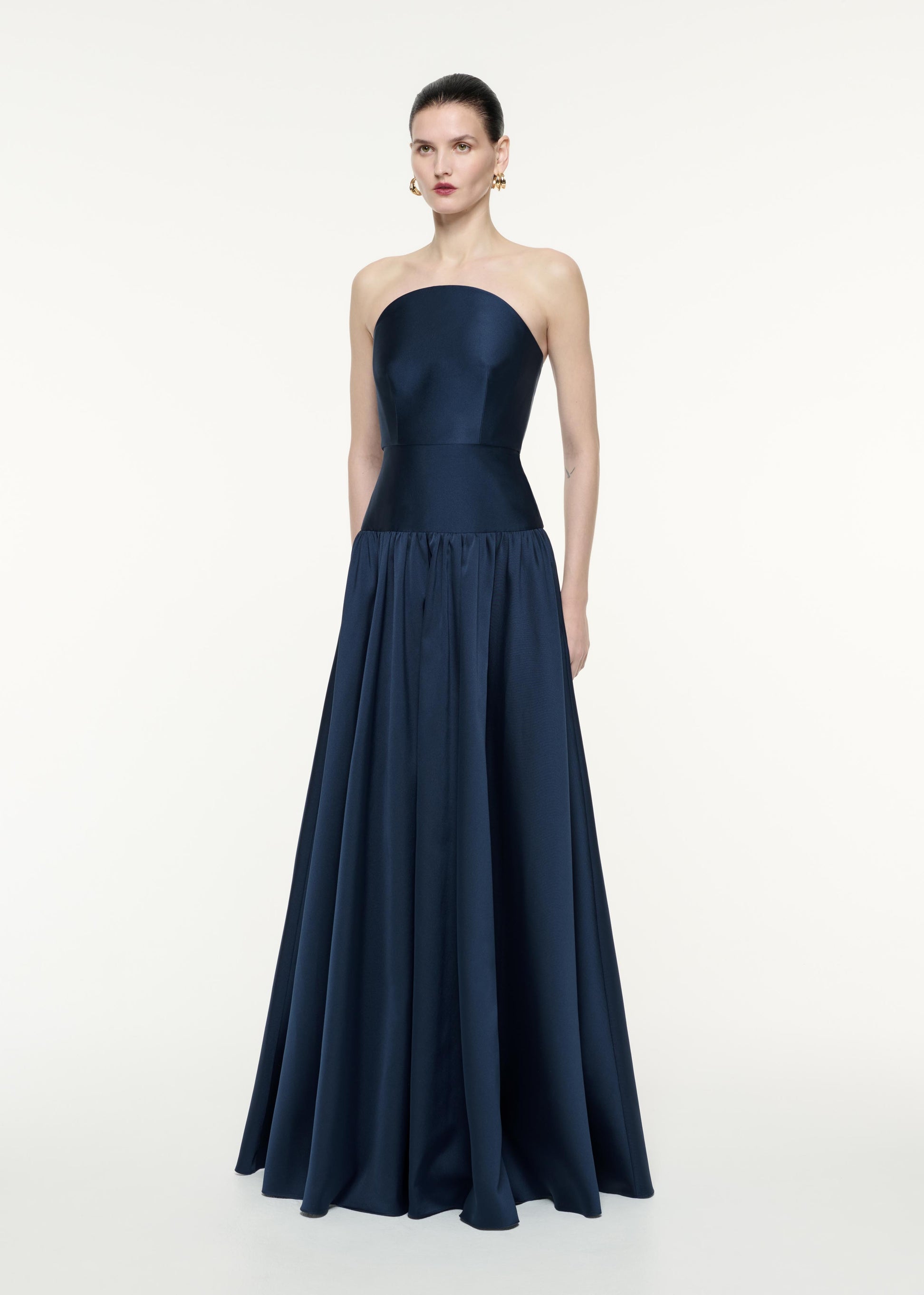 A side view image of a model wearing the Strapless Taffeta Gown in Navy