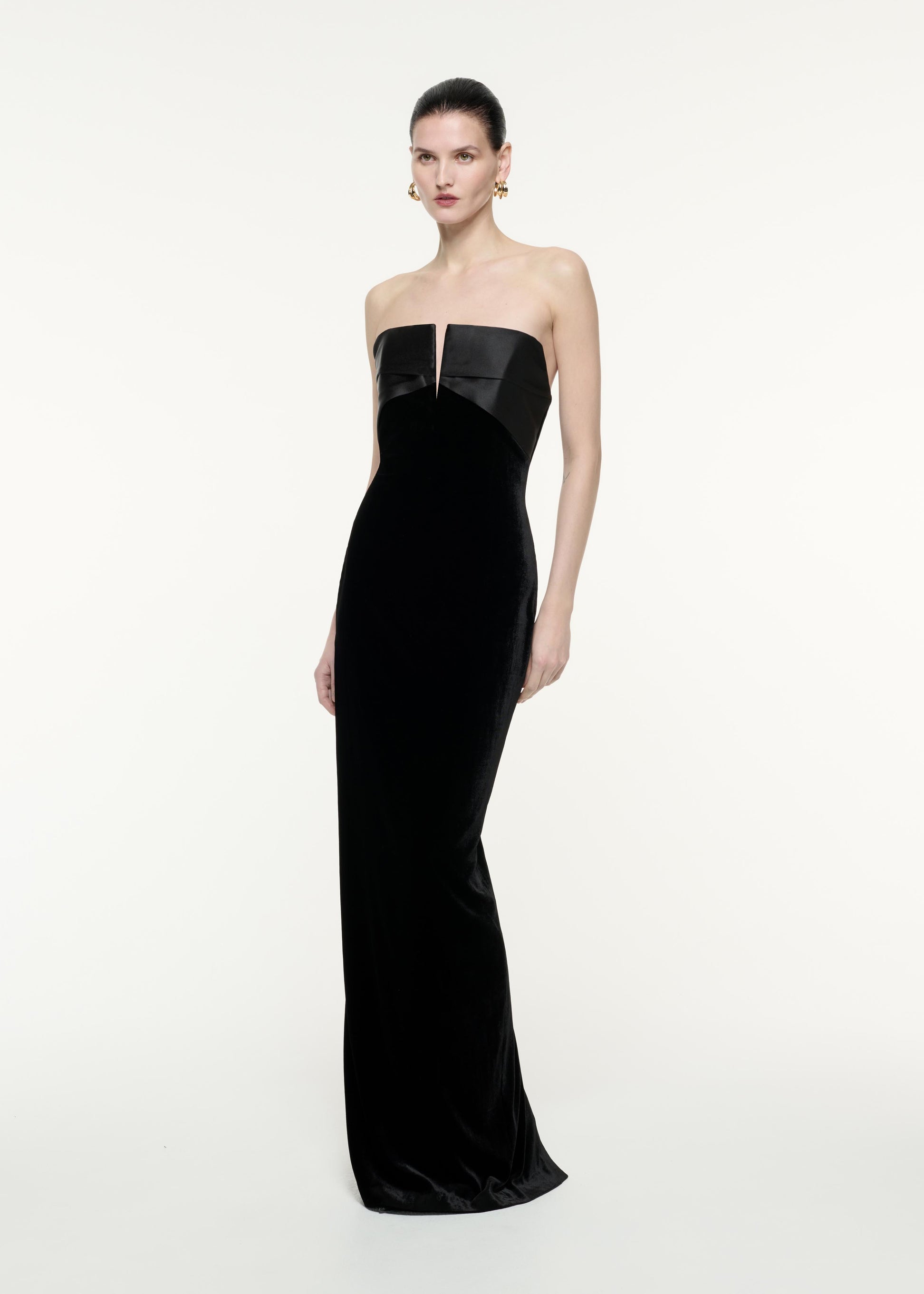 A side view image of a model wearing the Strapless Velvet Gown in Black