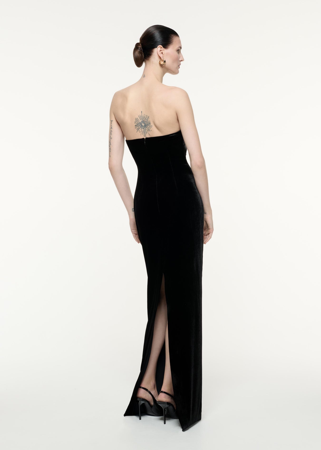 A back view image of a model wearing the Strapless Velvet Gown in Black