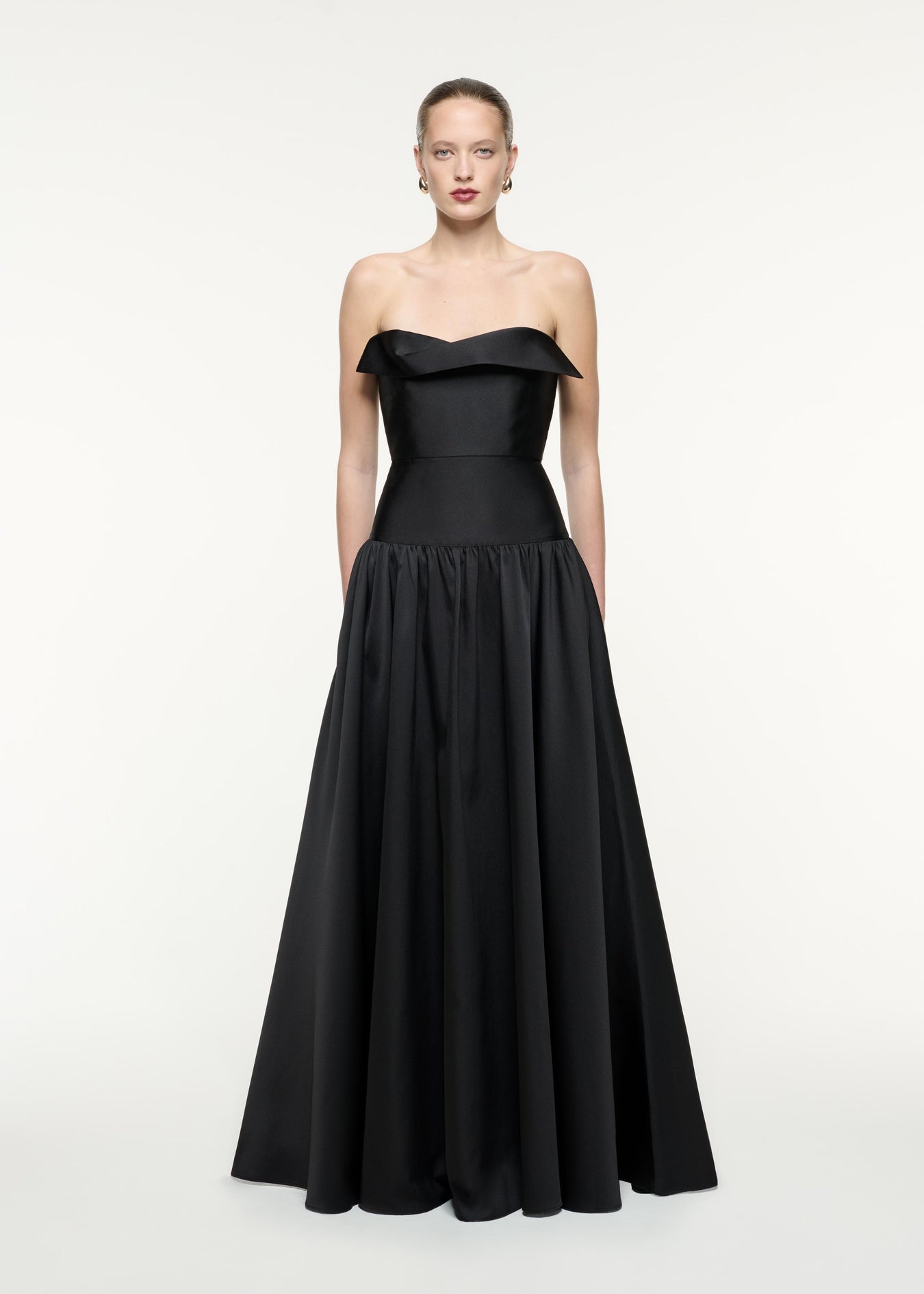 A front view image of a model wearing the Strapless Taffeta Gown in Black