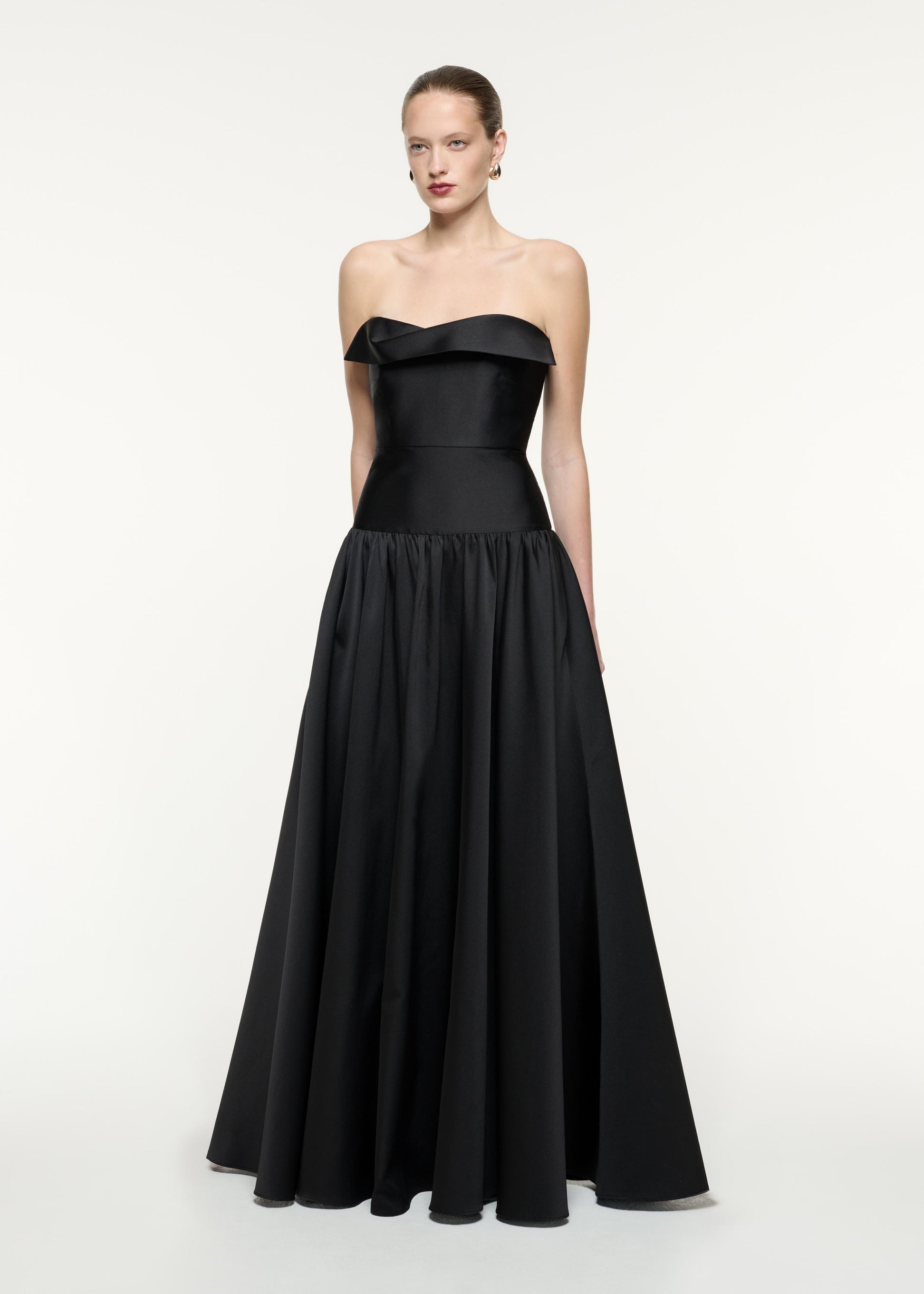 A side view image of a model wearing the Strapless Taffeta Gown in Black