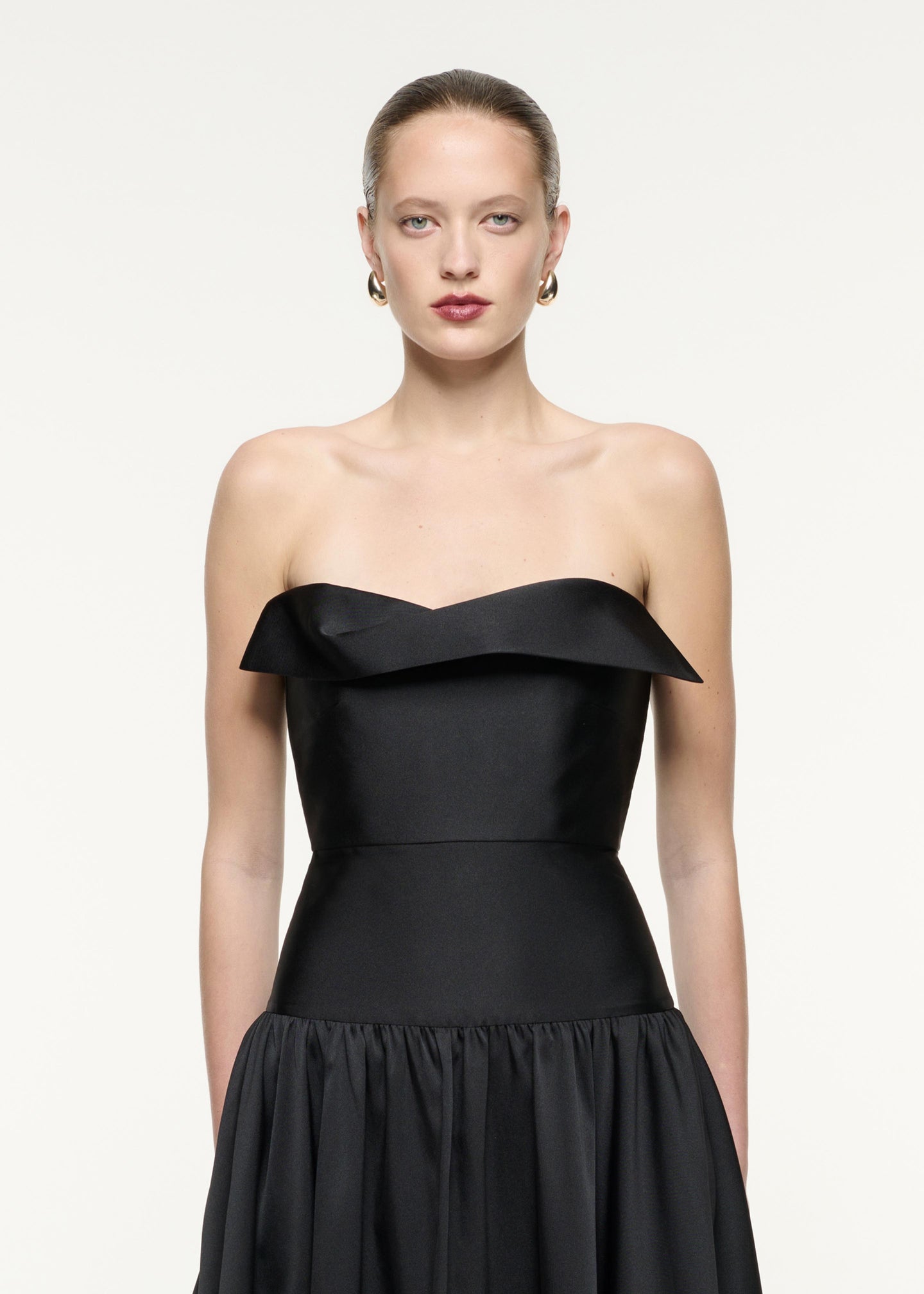 A close up image of a model wearing the Strapless Taffeta Gown in Black