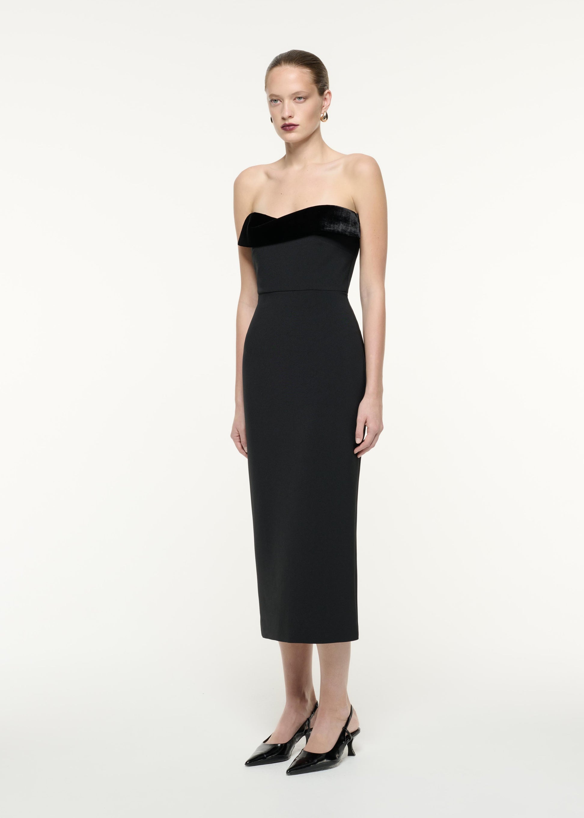 A side view image of a model wearing the Strapless Crepe Midi Dress in Black