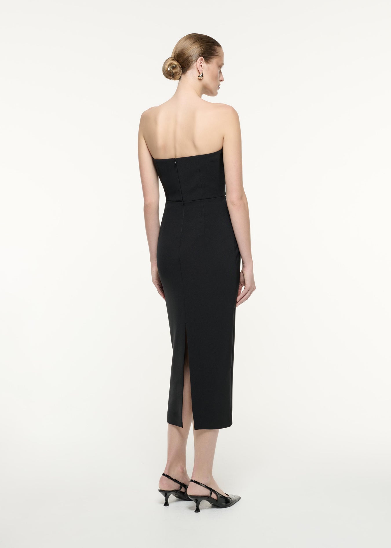 A back view image of a model wearing the Strapless Crepe Midi Dress in Black