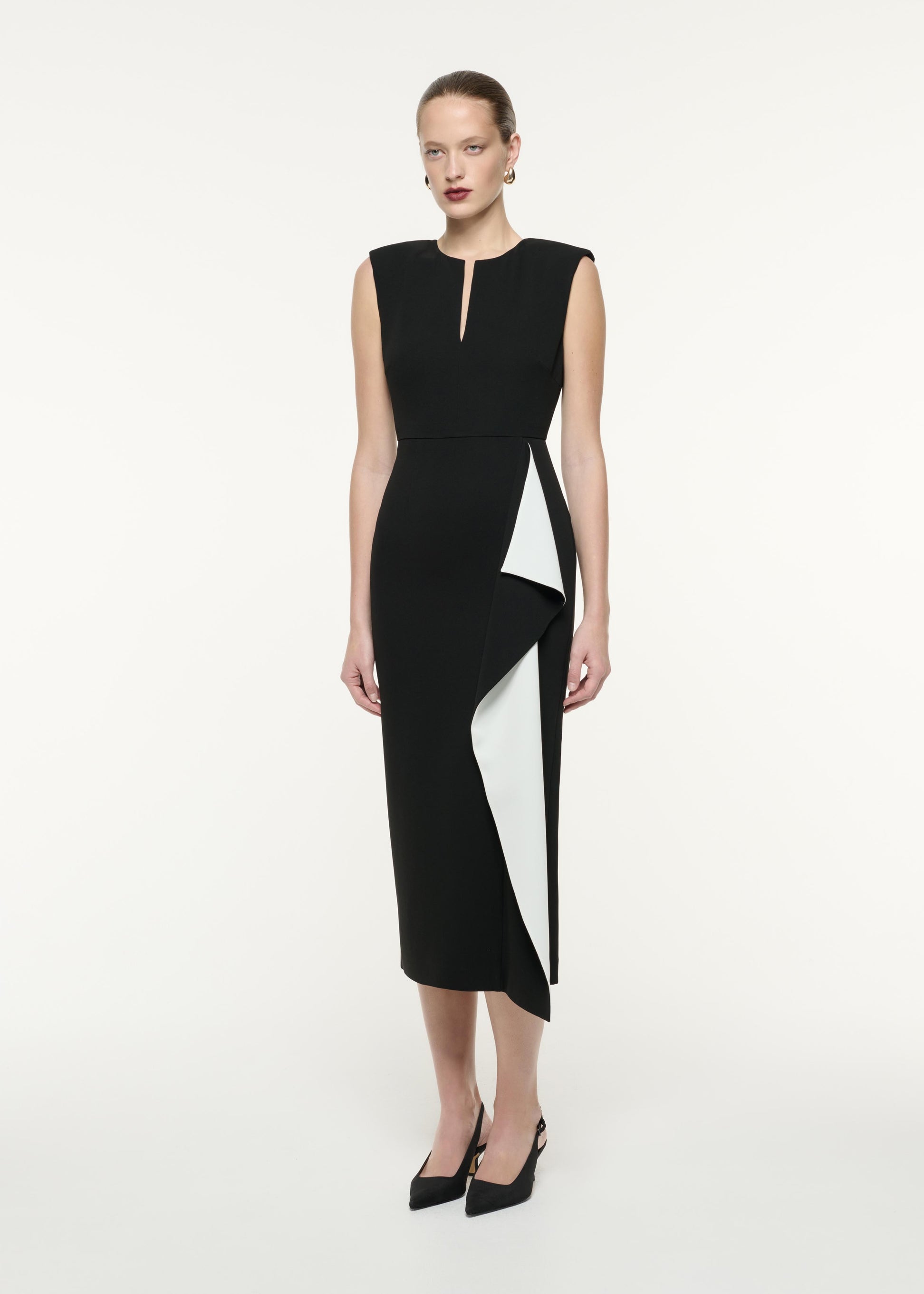 A side view image of a model wearing the Heavy Cady Ruffle Midi Dress in Monochrome