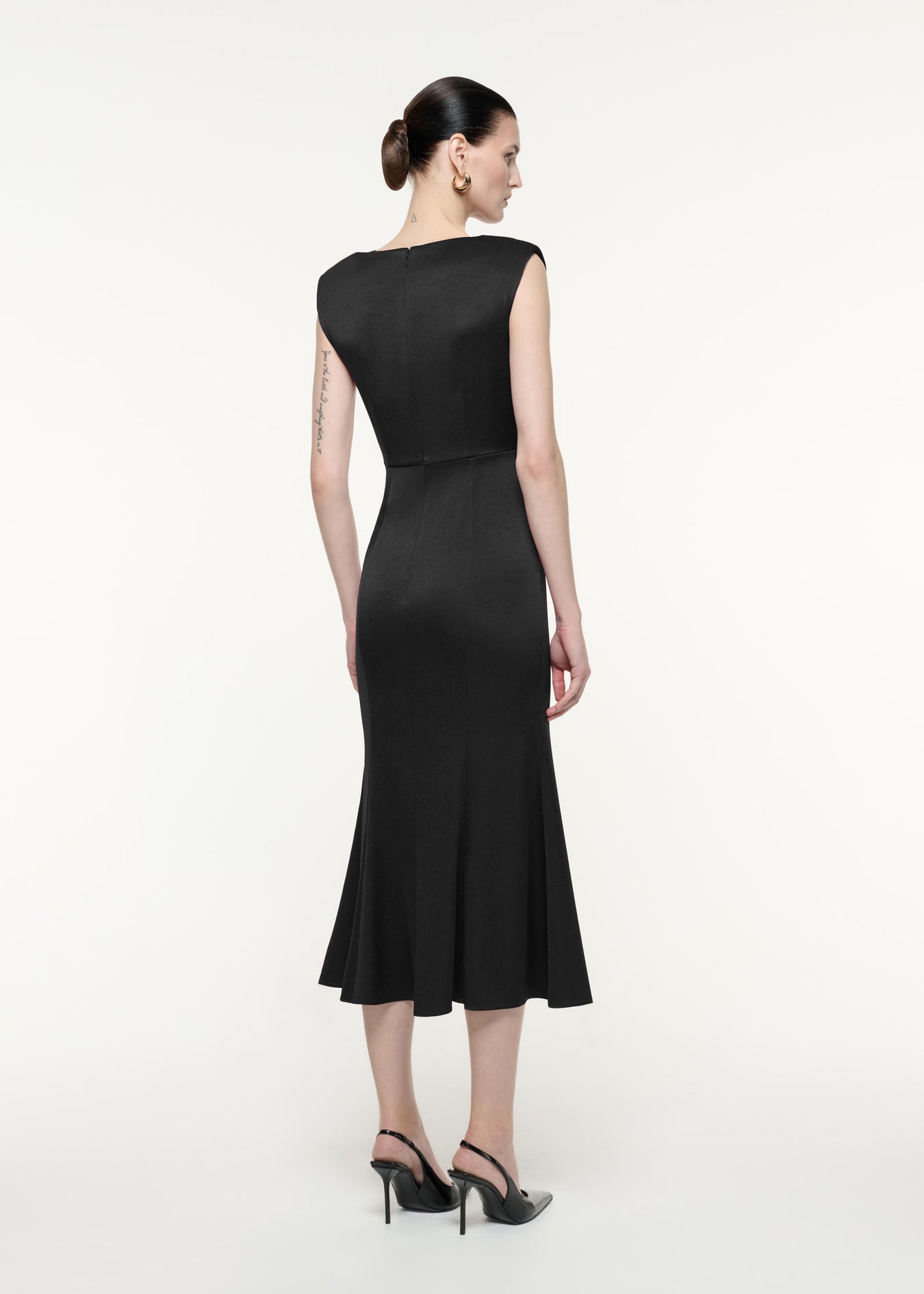 A back view image of a model wearing the Satin Crepe Midi Dress in Black