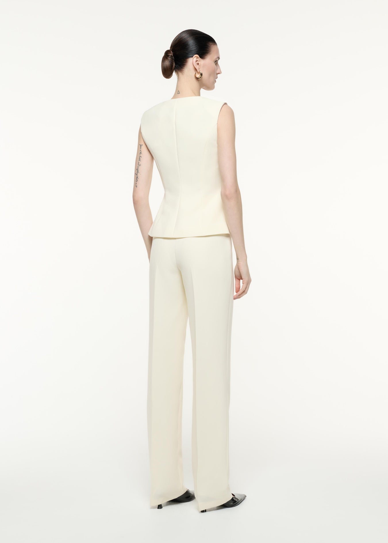 A back view image of a model wearing the Crepe Trouser in Cream