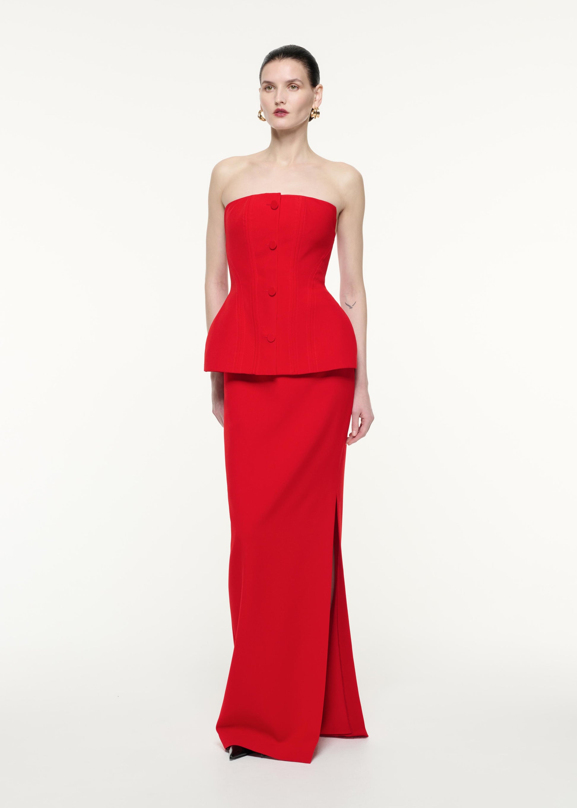 A side view image of a model wearing the Strapless Crepe Gown in Red