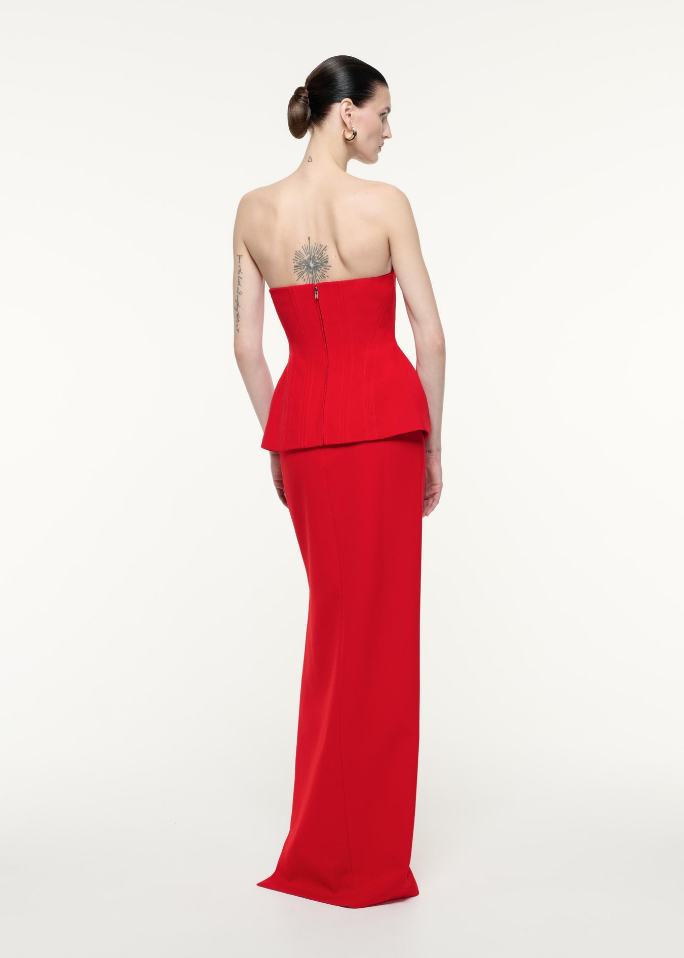 A back view image of a model wearing the Strapless Crepe Gown in Red