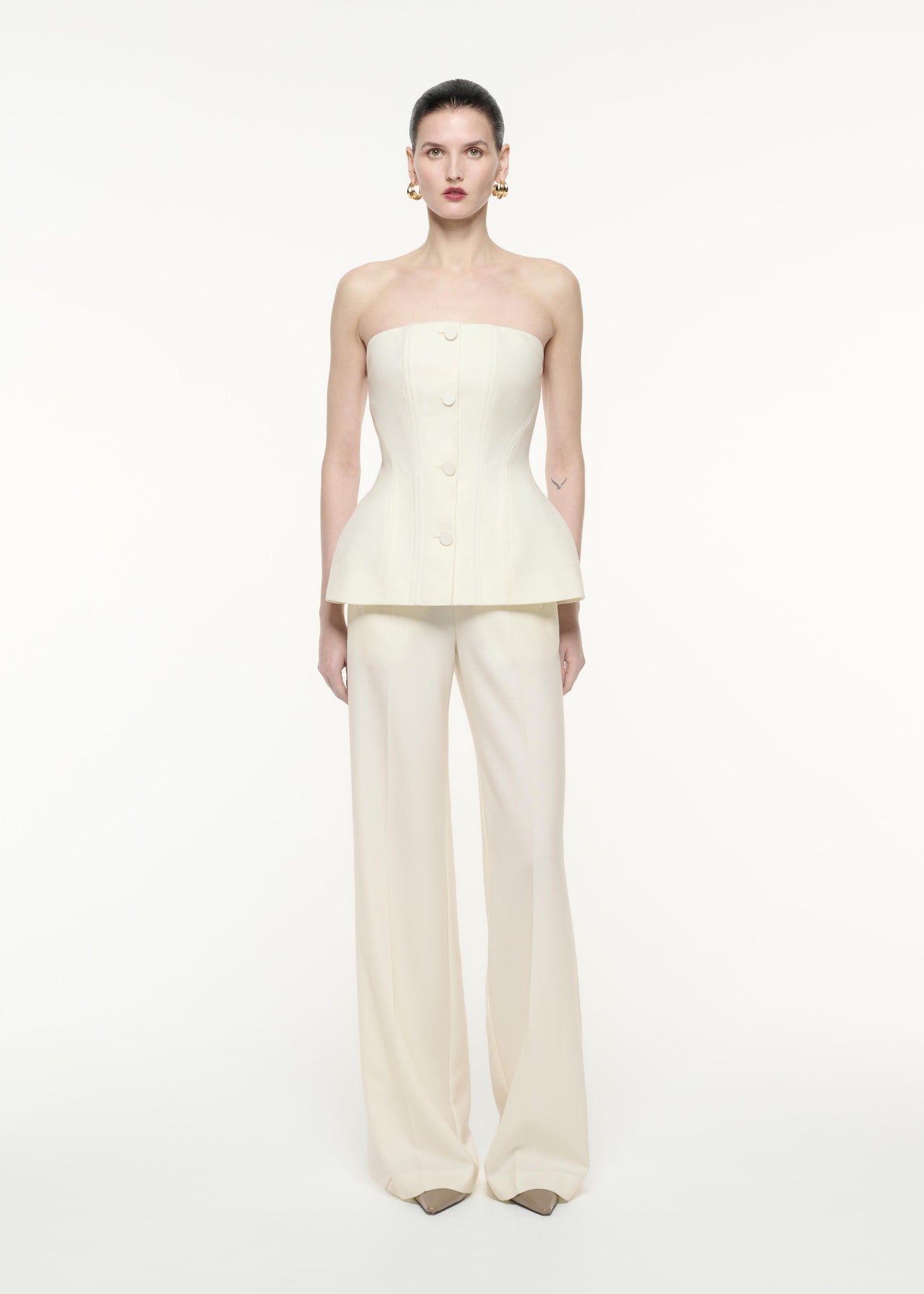 A front view image of a model wearing the Strapless Tailoring Wool Jumpsuit in Cream