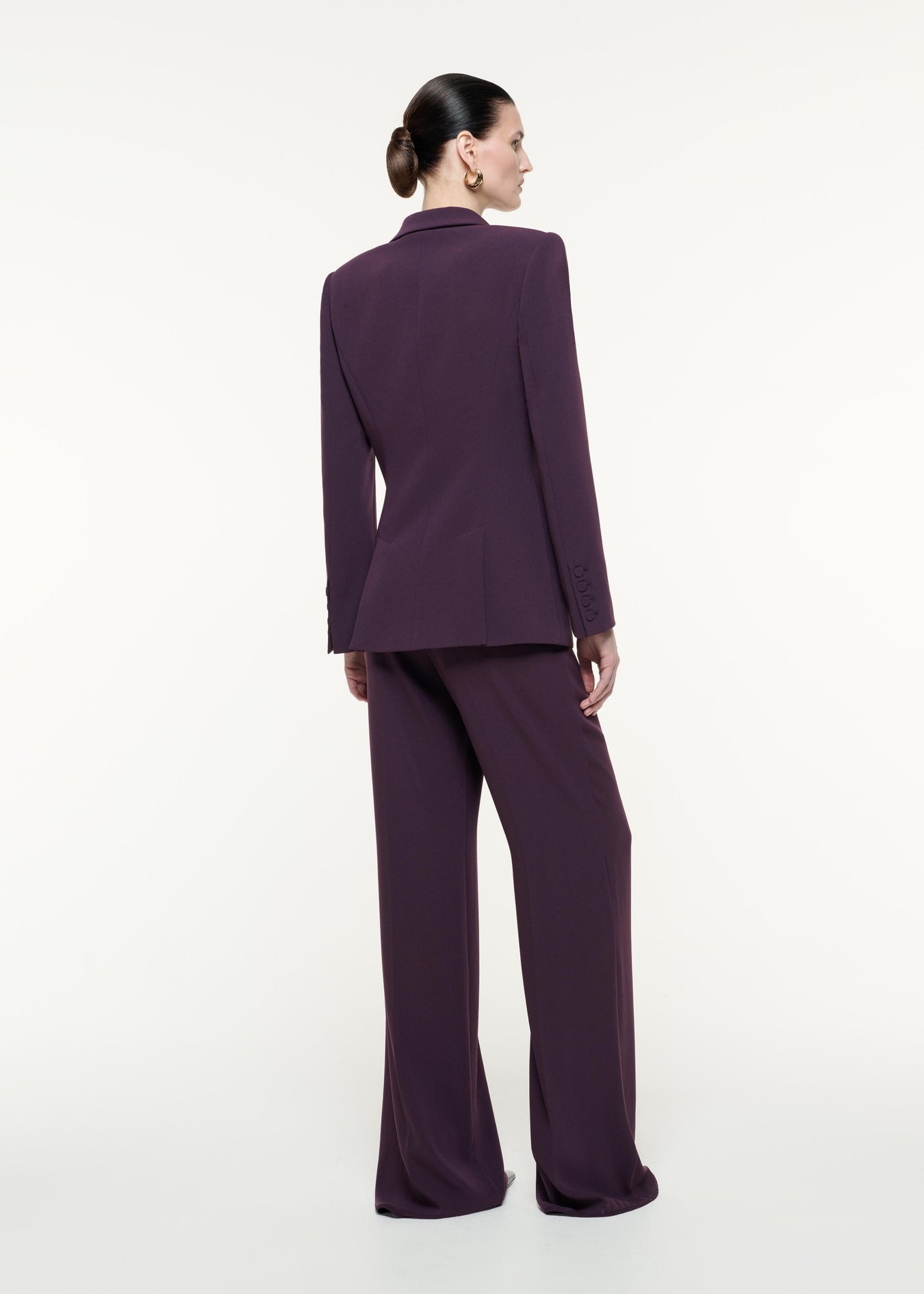 A back view image of a model wearing the Satin Crepe Jacket in Aubergine