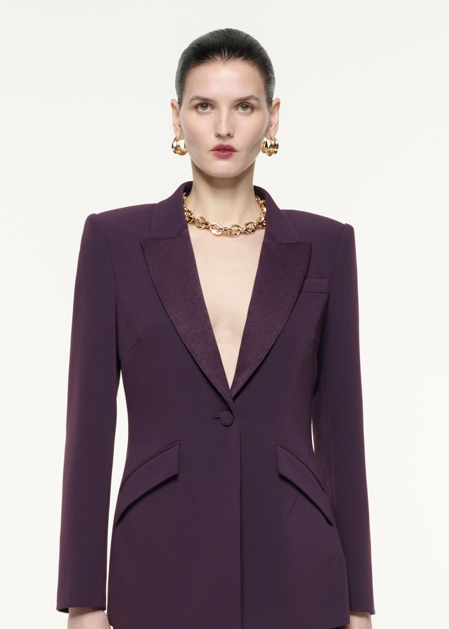 A close up image of a model wearing the Satin Crepe Jacket in Aubergine