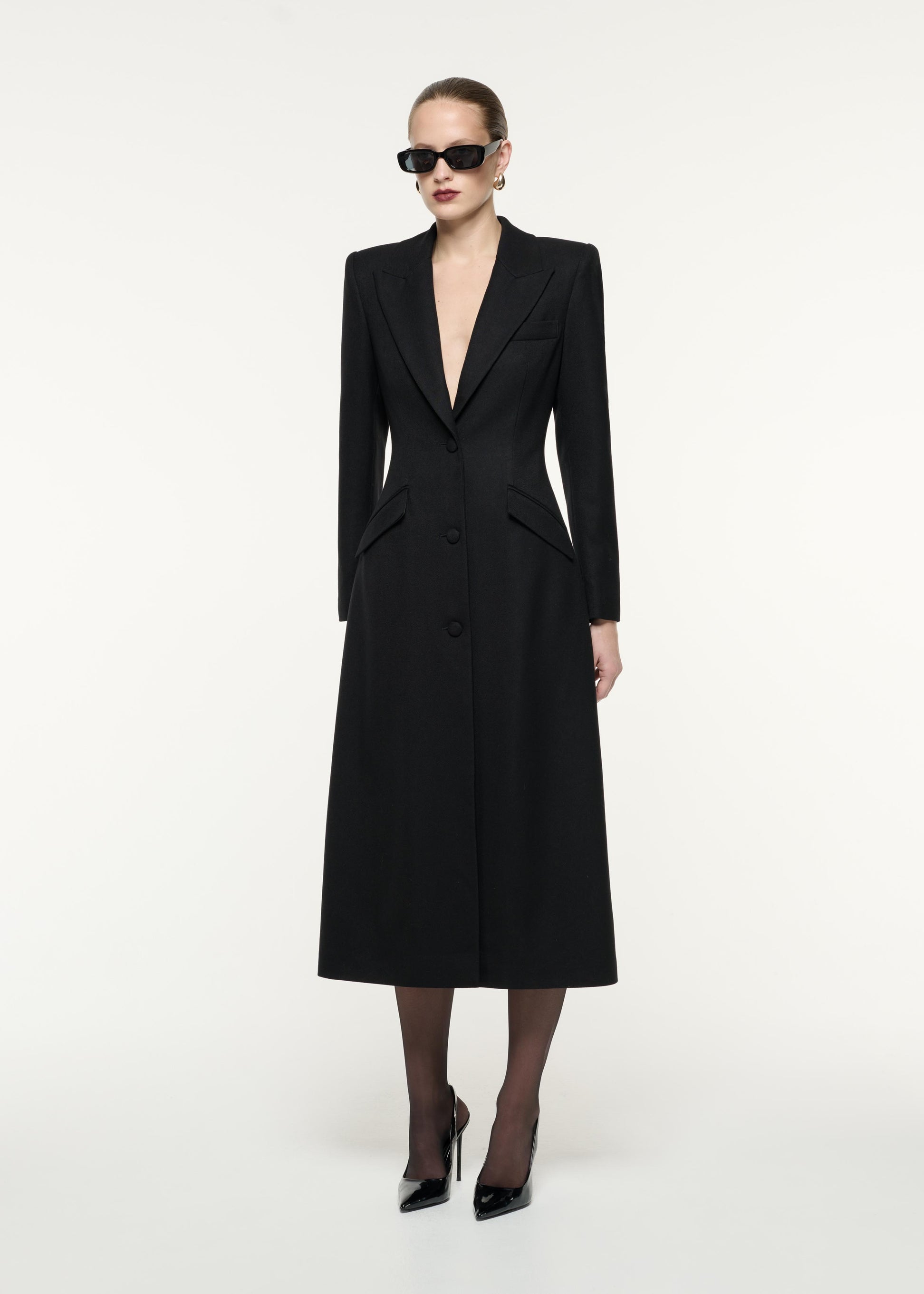 A side view image of a model wearing the Wool Twill Tailored Coat in Black