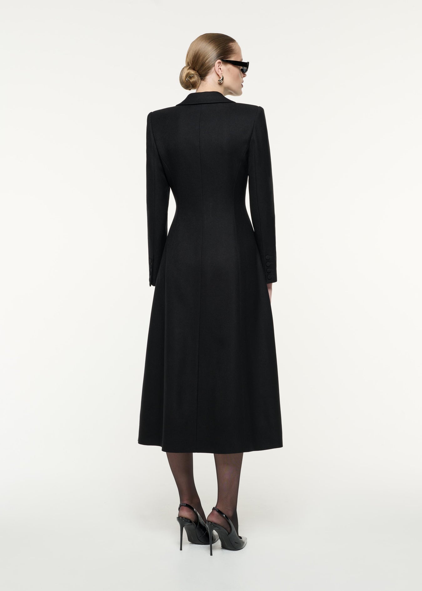 A back view image of a model wearing the Wool Twill Tailored Coat in Black