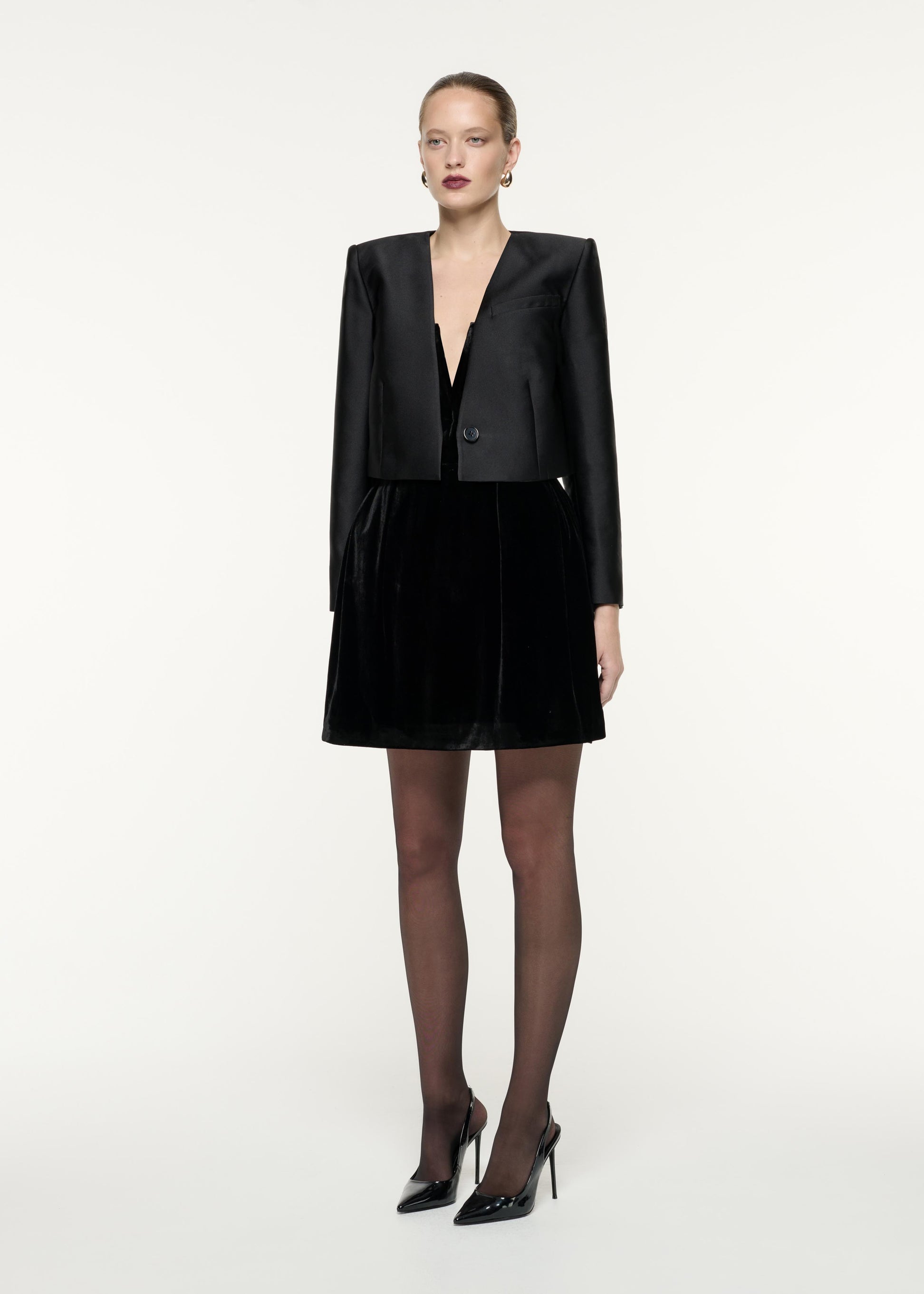 A side view image of a model wearing the Cropped Taffeta Jacket in Black