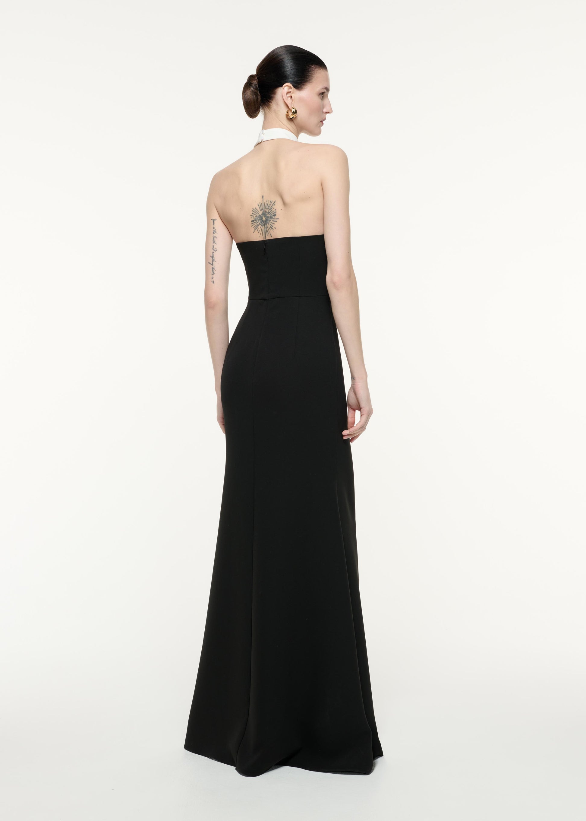 A back view image of a model wearing the Halter Neck Gown in Monochrome