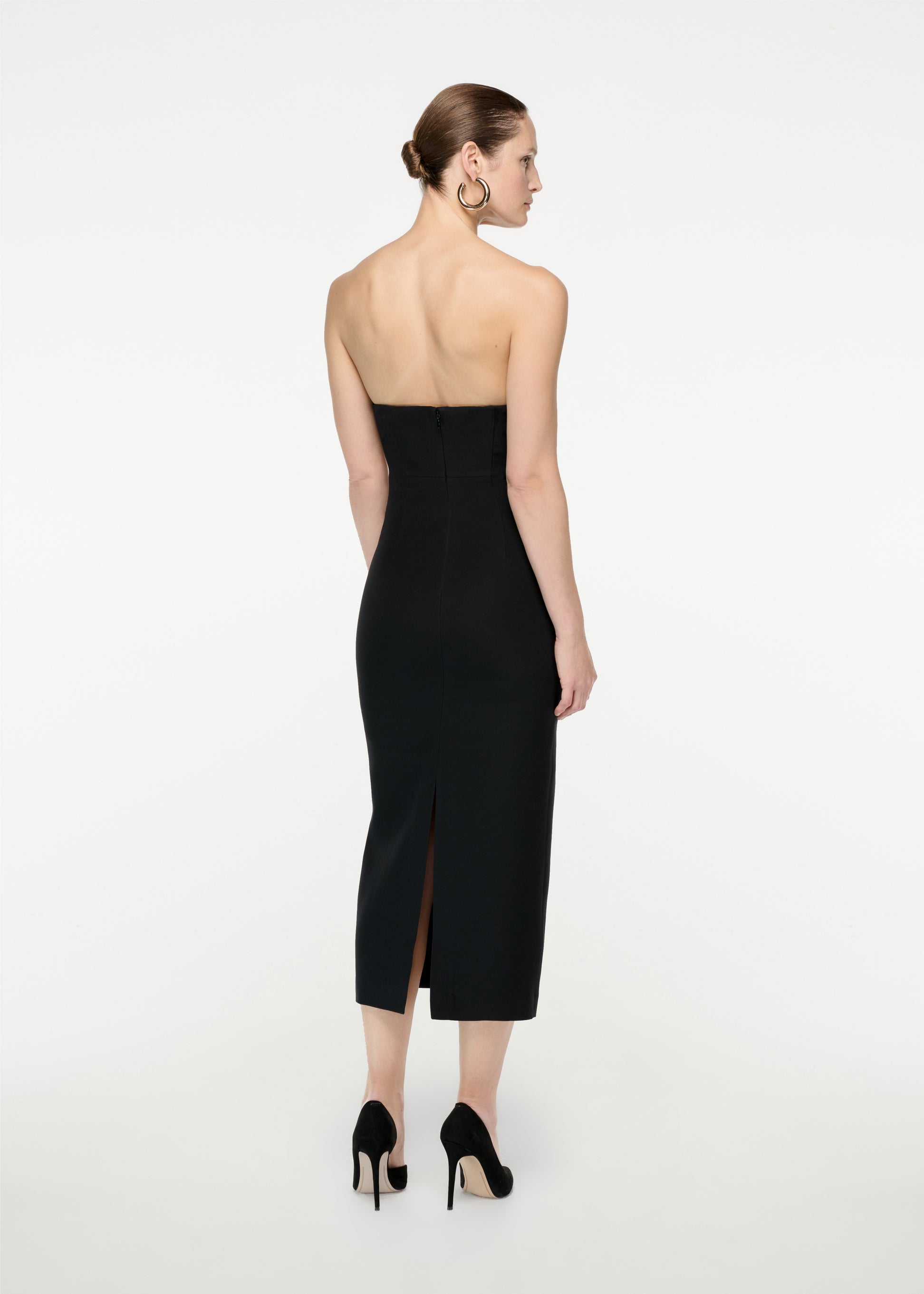 The back of a woman wearing the Strapless Silk Wool Diamante Midi Dress in Black