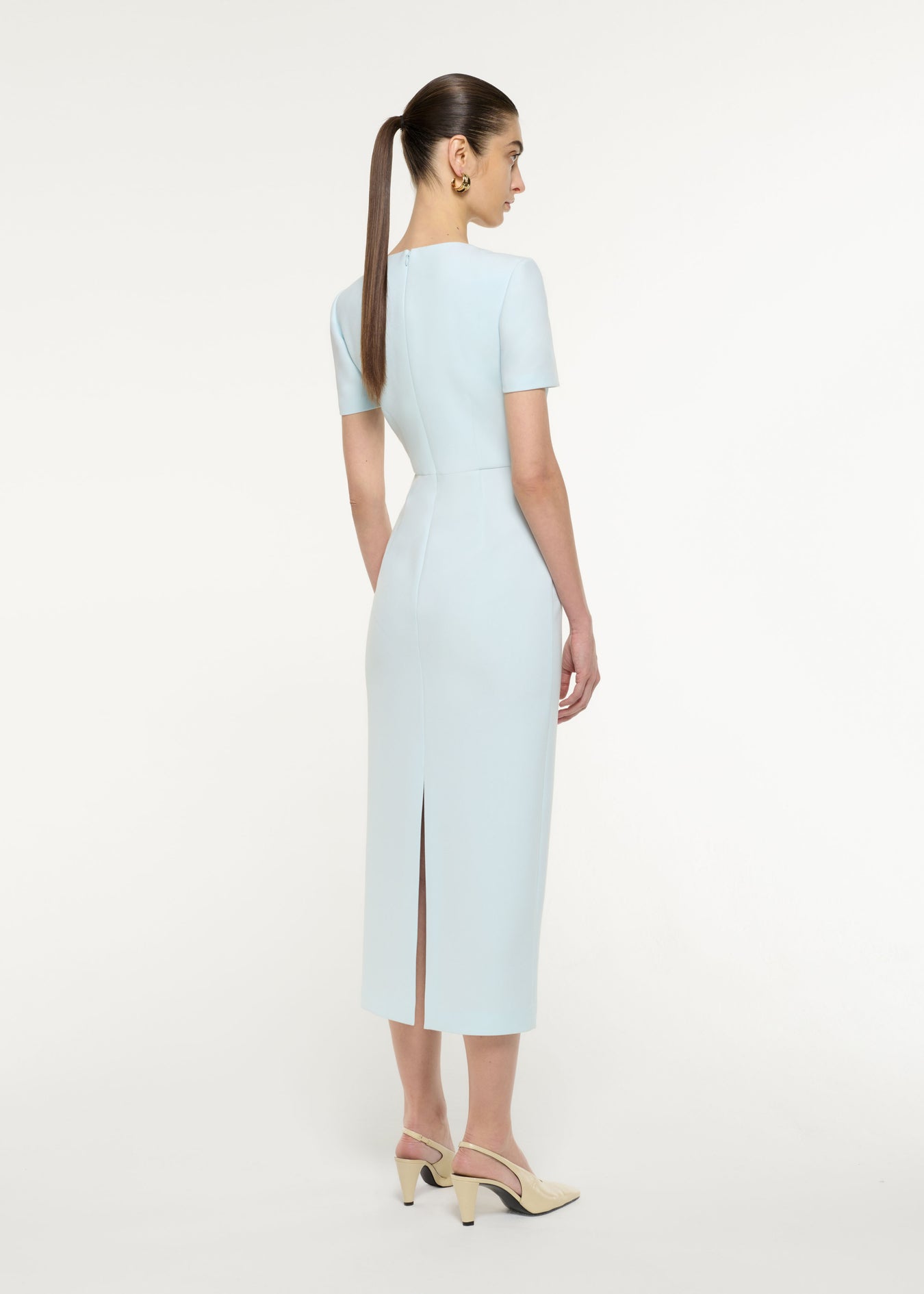 Back view of a model wearing the Asymmetric Drape Midi Dress in Blue