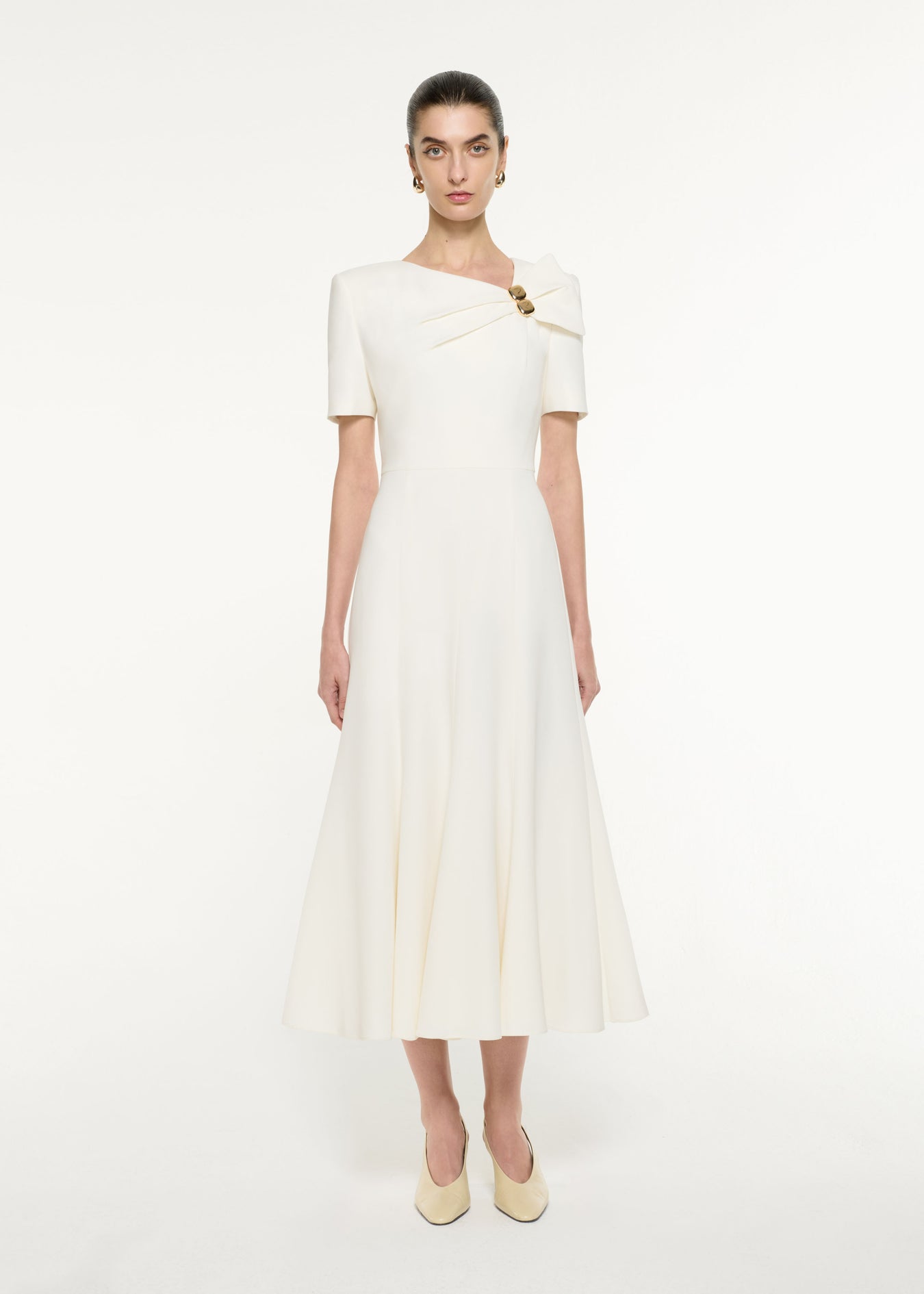 Front view of a model wearing the Bow Drape Light Cady Midi Dress in Cream