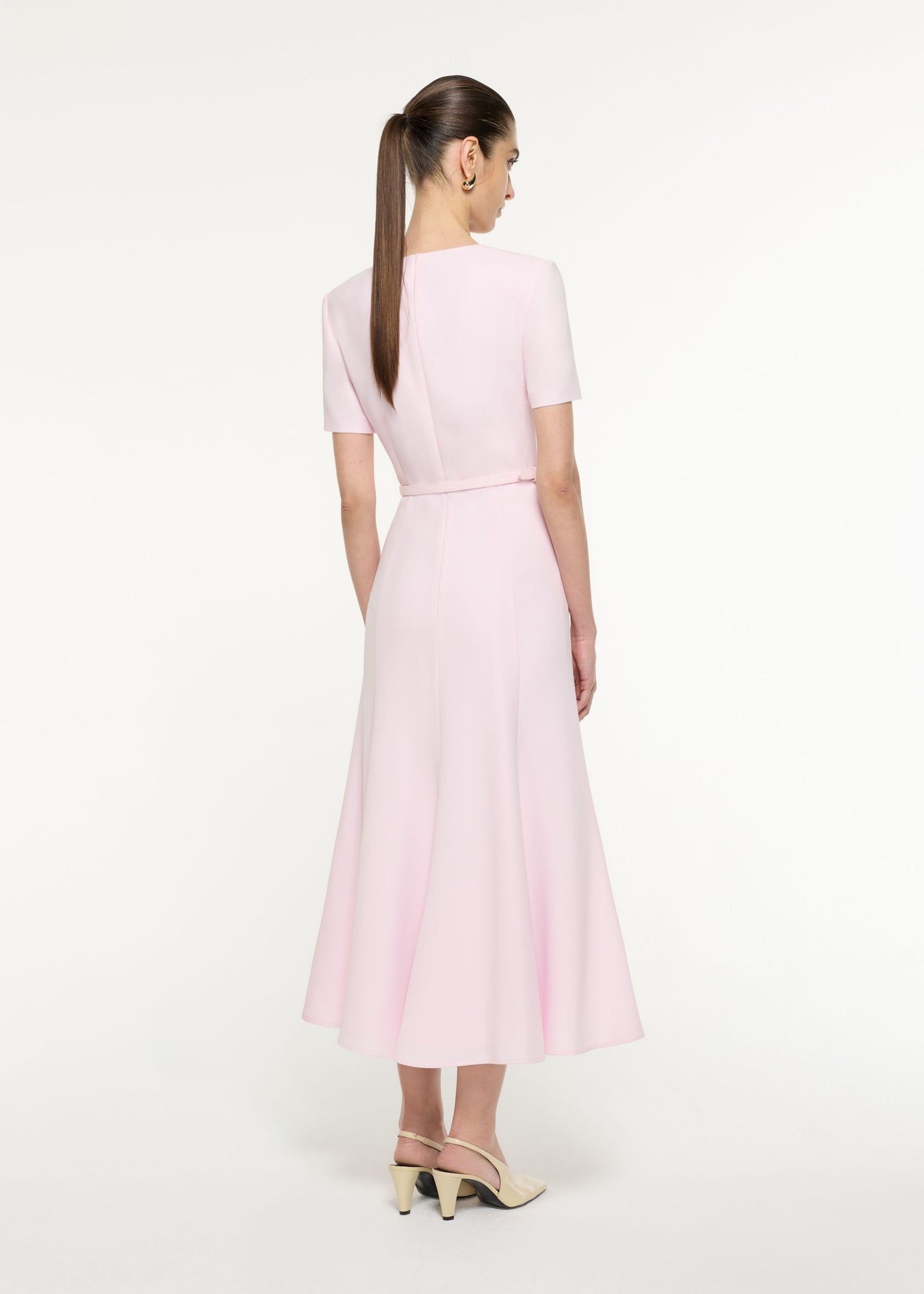 Back view of a model wearing the Tri-fold Drape Midi Dress in Light Pink 