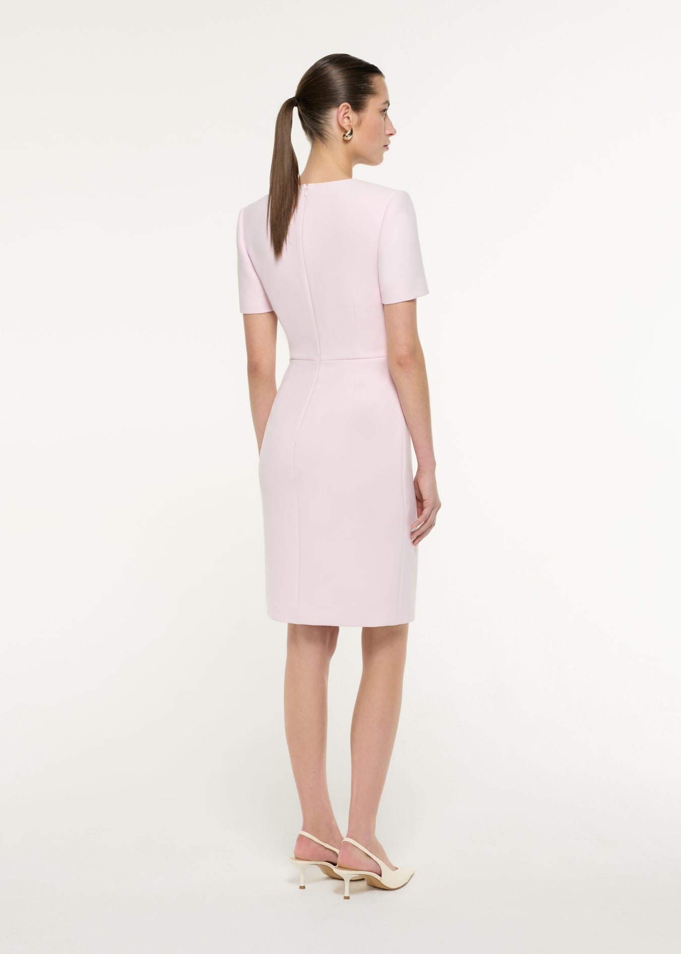 Back view of a model wearing the Diagonal Fold Midi Dress in Light Pink