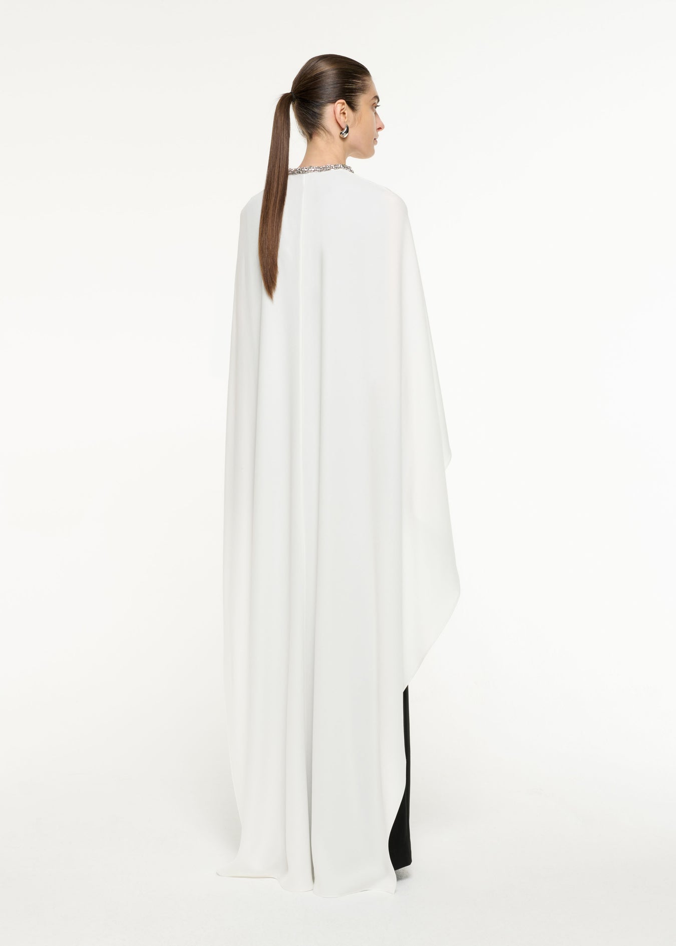 Back view of a model wearing the Satin Crepe Cape Gown in Monocrhome