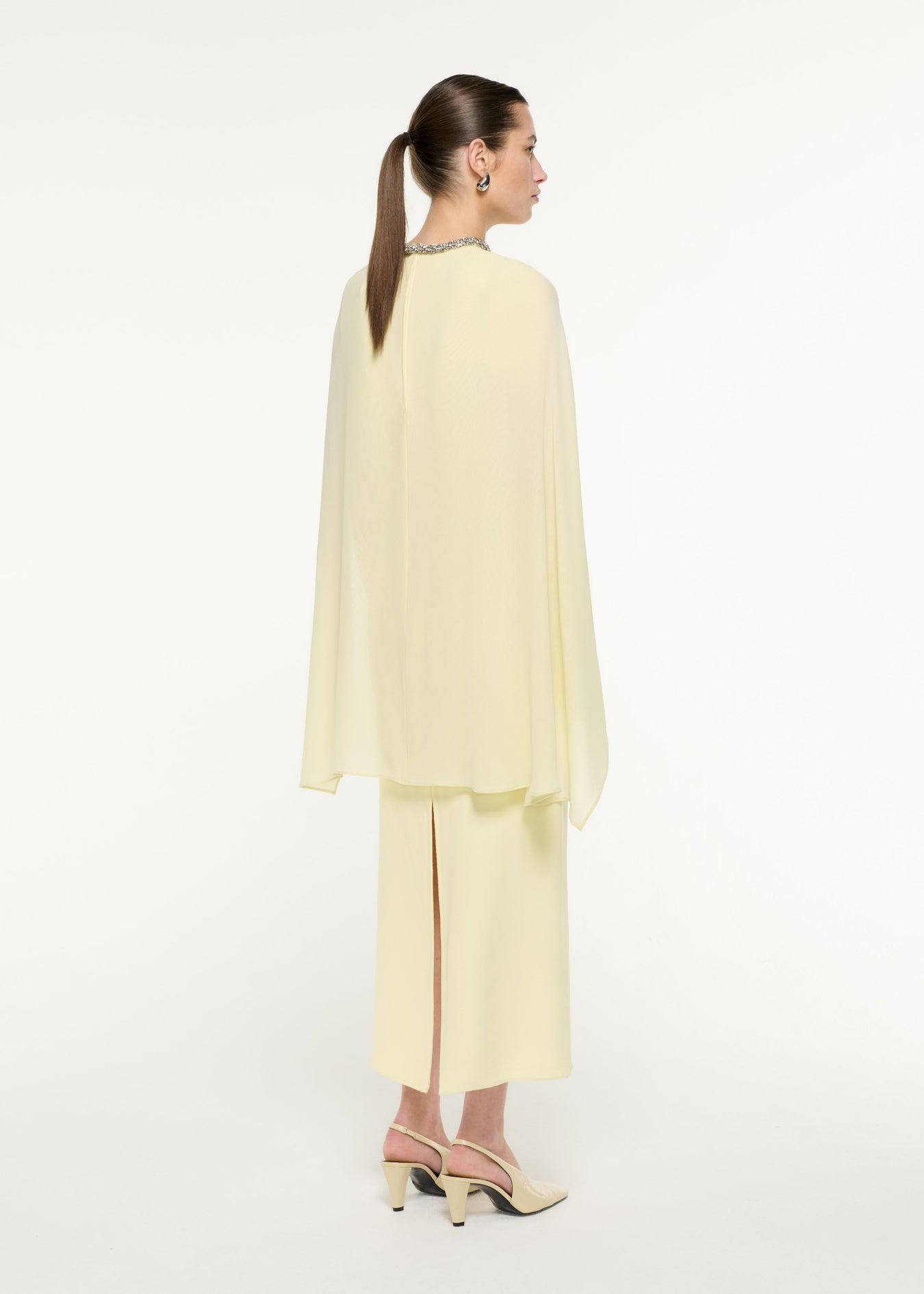 Back view of a model wearing the Silk Cape Maxi Dress in Light Yellow