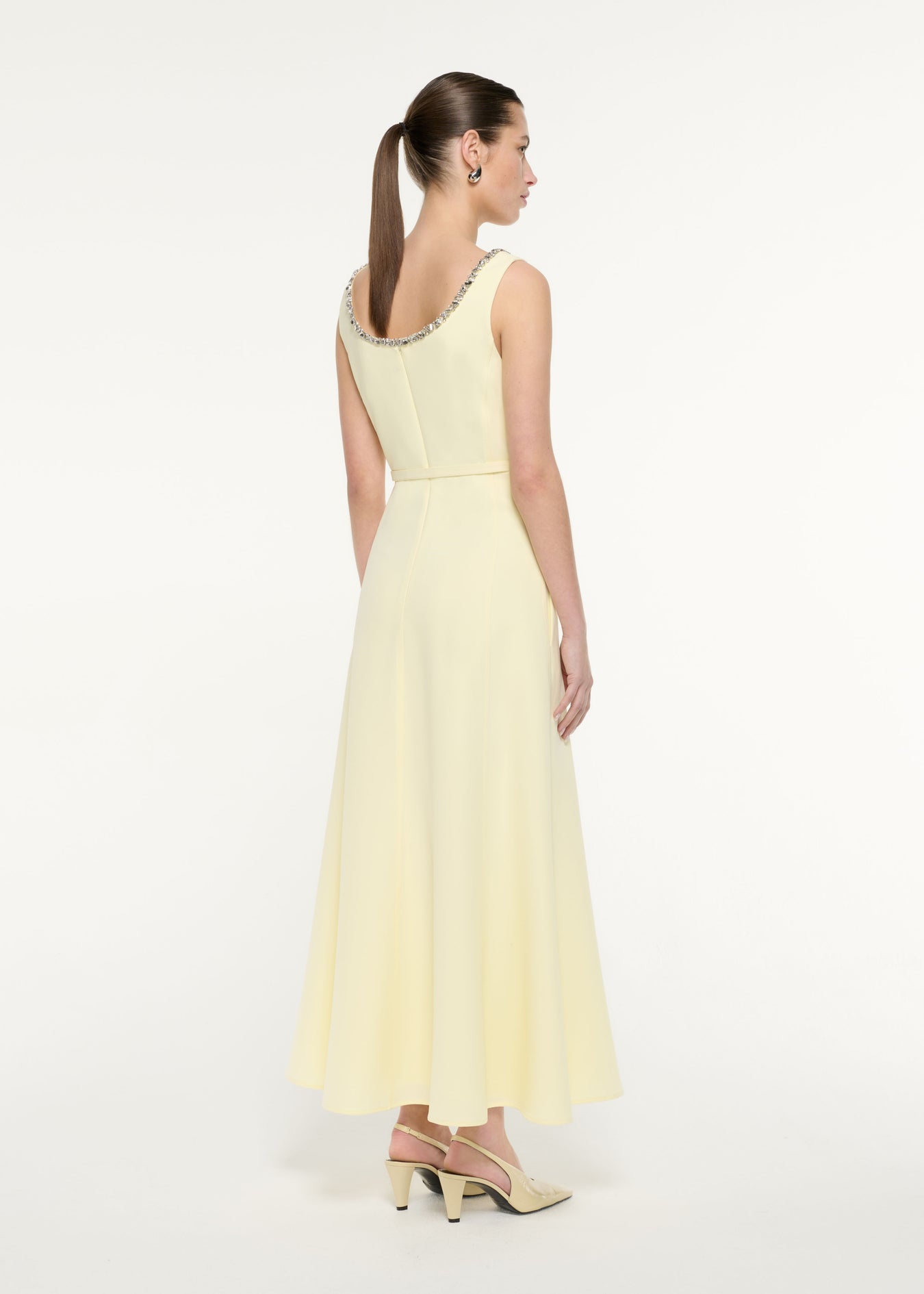 Back view of a model wearing the Embellished Heavy Cady Maxi Dress in Light Yellow