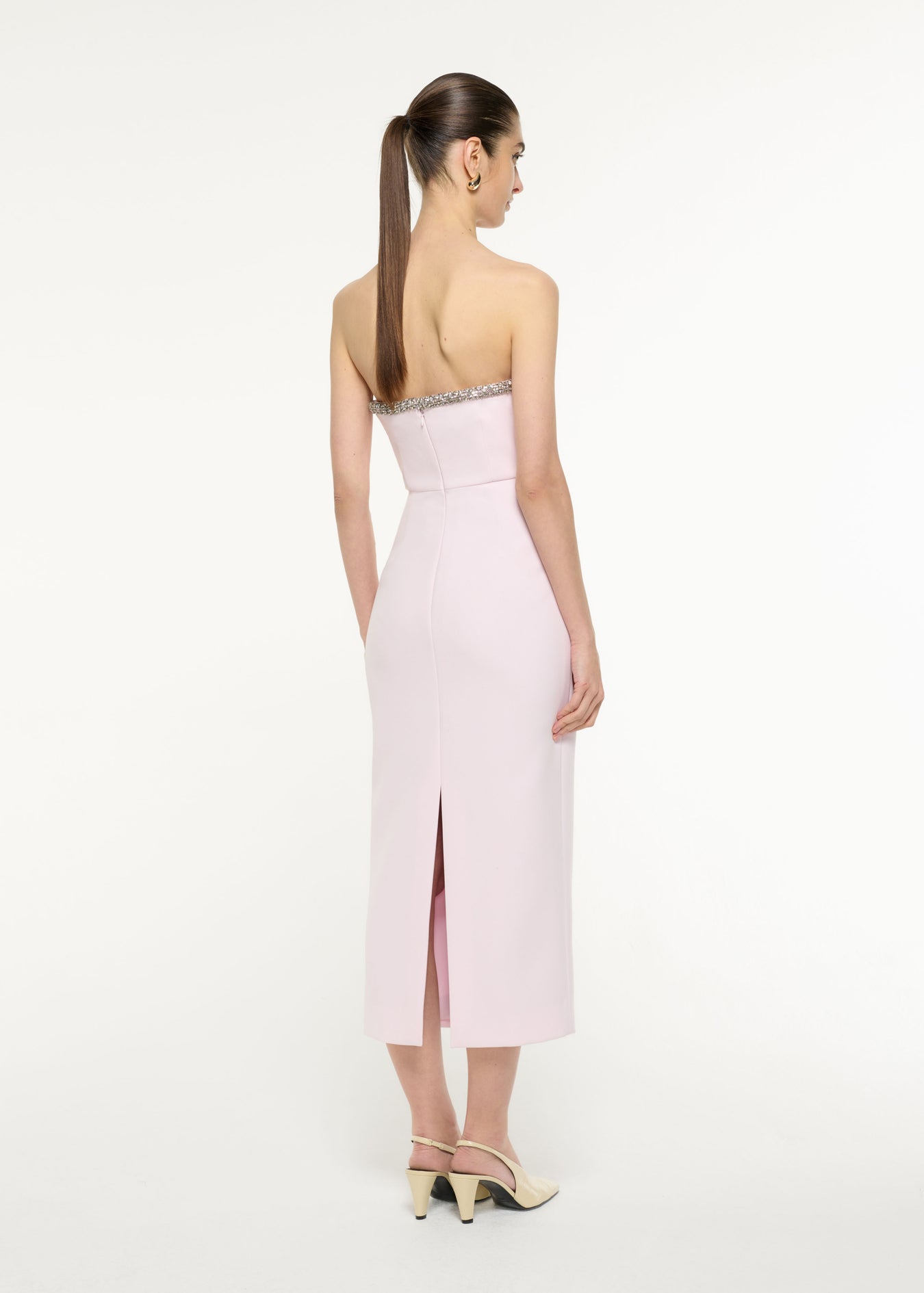 Back view of a model wearing the Sweetheart Embellished Midi Dress in light pink