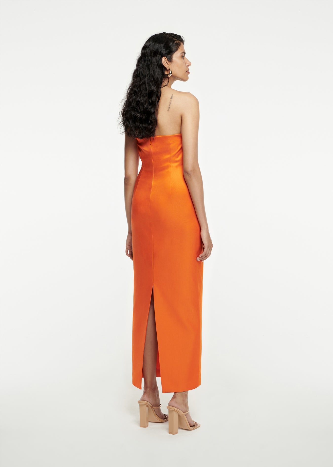 The back of a woman wearing the Strapless Satin Maxi Dress in Orange